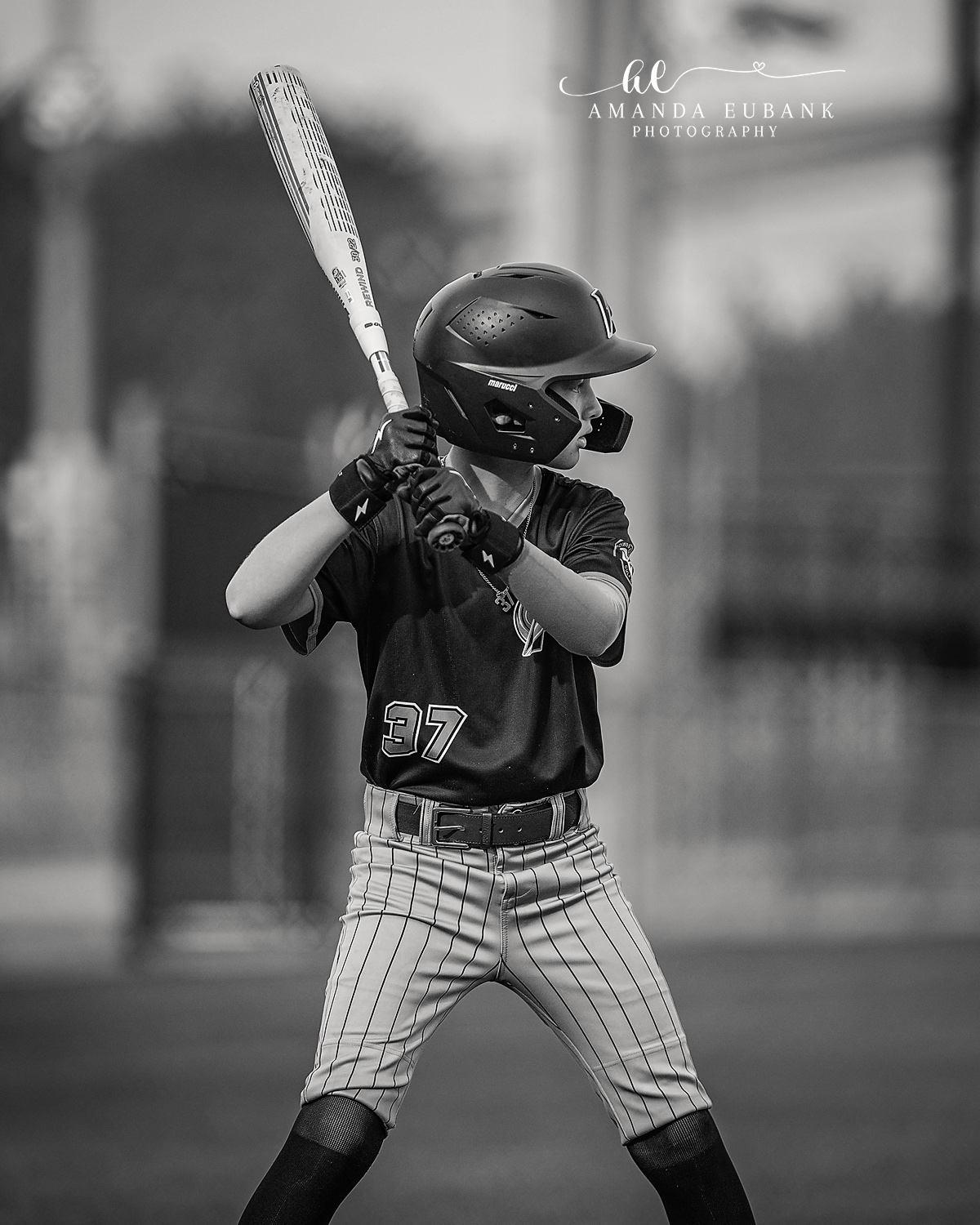 Batter Number 37 Black Jersey Stance | Hoover AL Travel Baseball Photographer Black and white image of a Power Kilcrease 11U batter in jersey number 37 and pinstripe pants holding a strong, squared batting stance with bat raised behind his head during a Hoover, Alabama tournament game.