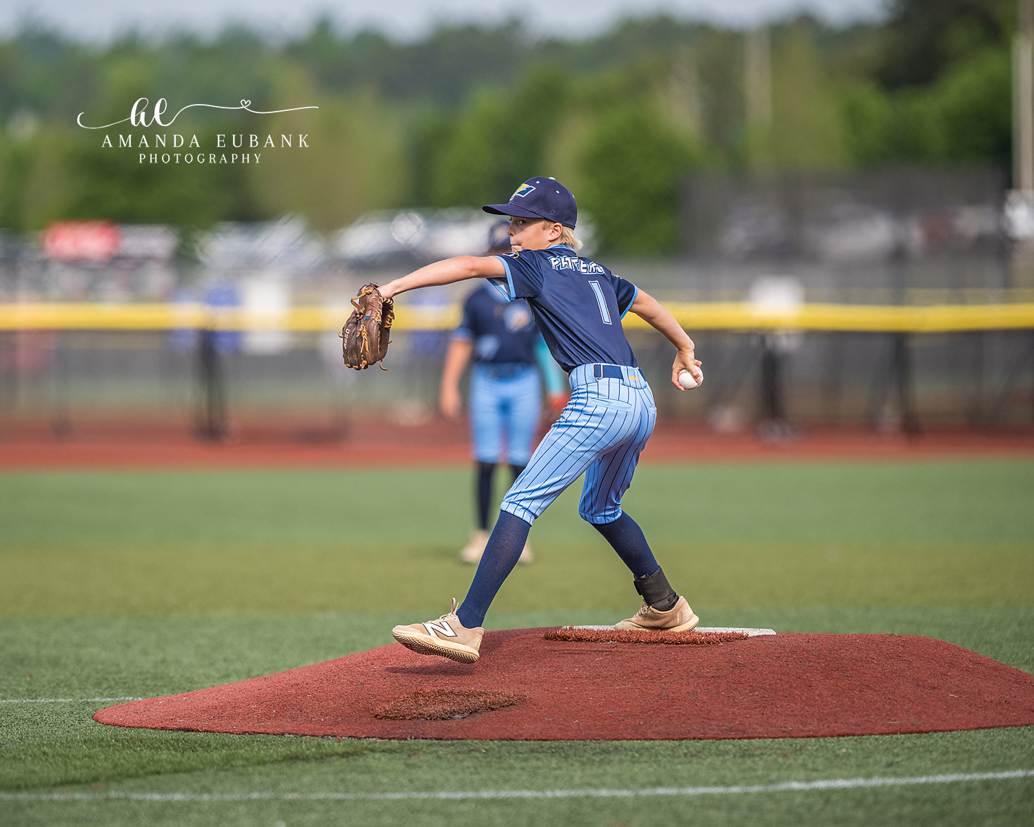 Pitcher Number 1 Wind-Up From Behind | Hoover AL Travel Baseball Photographer Power Kilcrease 11U pitcher number 1 begins his wind-up on the red dirt mound viewed from behind during a Hoover, Alabama travel baseball tournament game.