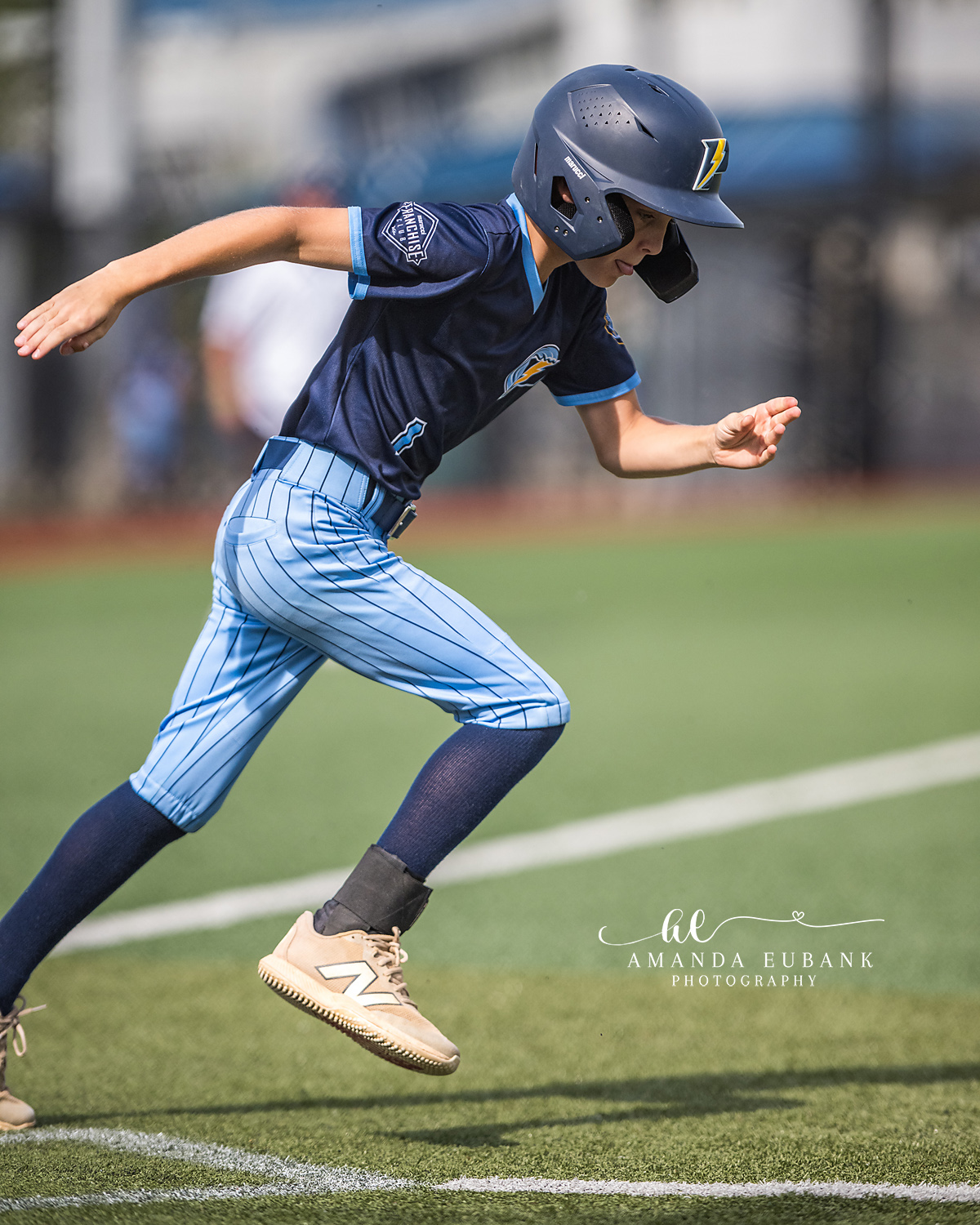 Baserunner Sprint Between Bases | Hoover AL Travel Baseball Photographer Power Kilcrease 11U baserunner explodes mid-stride between bases with helmet on, navy jersey, and light blue pinstripe pants during a Hoover, Alabama tournament game.