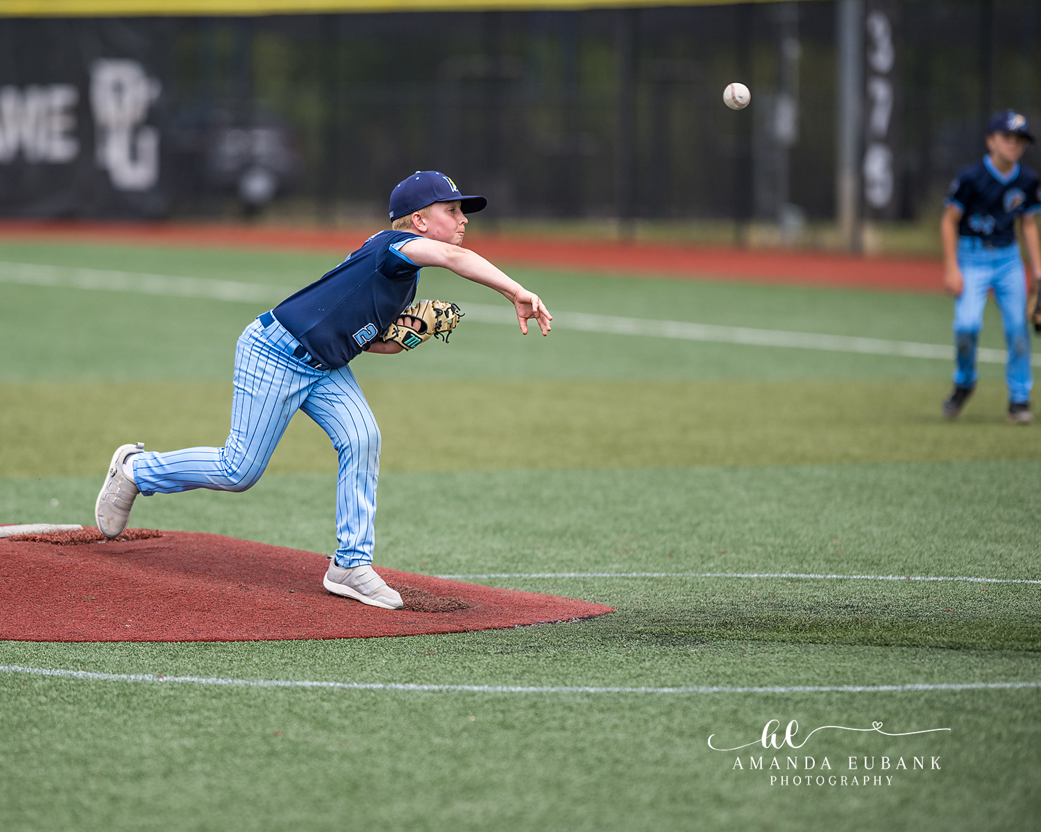 Pitcher Full Follow Through Ball Mid-Air | Hoover AL Travel Baseball Photographer Power Kilcrease 11U pitcher finishes his full follow-through with the released baseball visible mid-air heading to home plate during a Hoover, Alabama tournament game.
