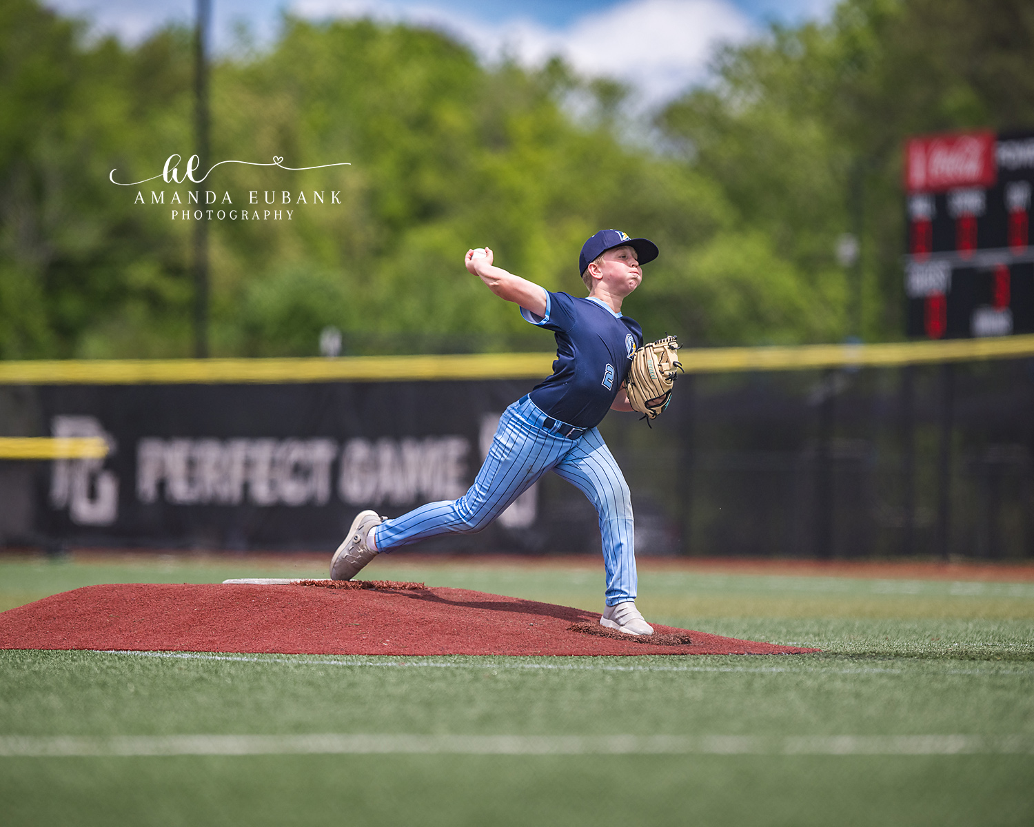 Pitcher Cocked at Perfect Game | Hoover AL Travel Baseball Photographer Power Kilcrease 11U pitcher reaches the cocked position on the mound with a Perfect Game banner stretched across the outfield wall during a tournament game in Hoover, Alabama.