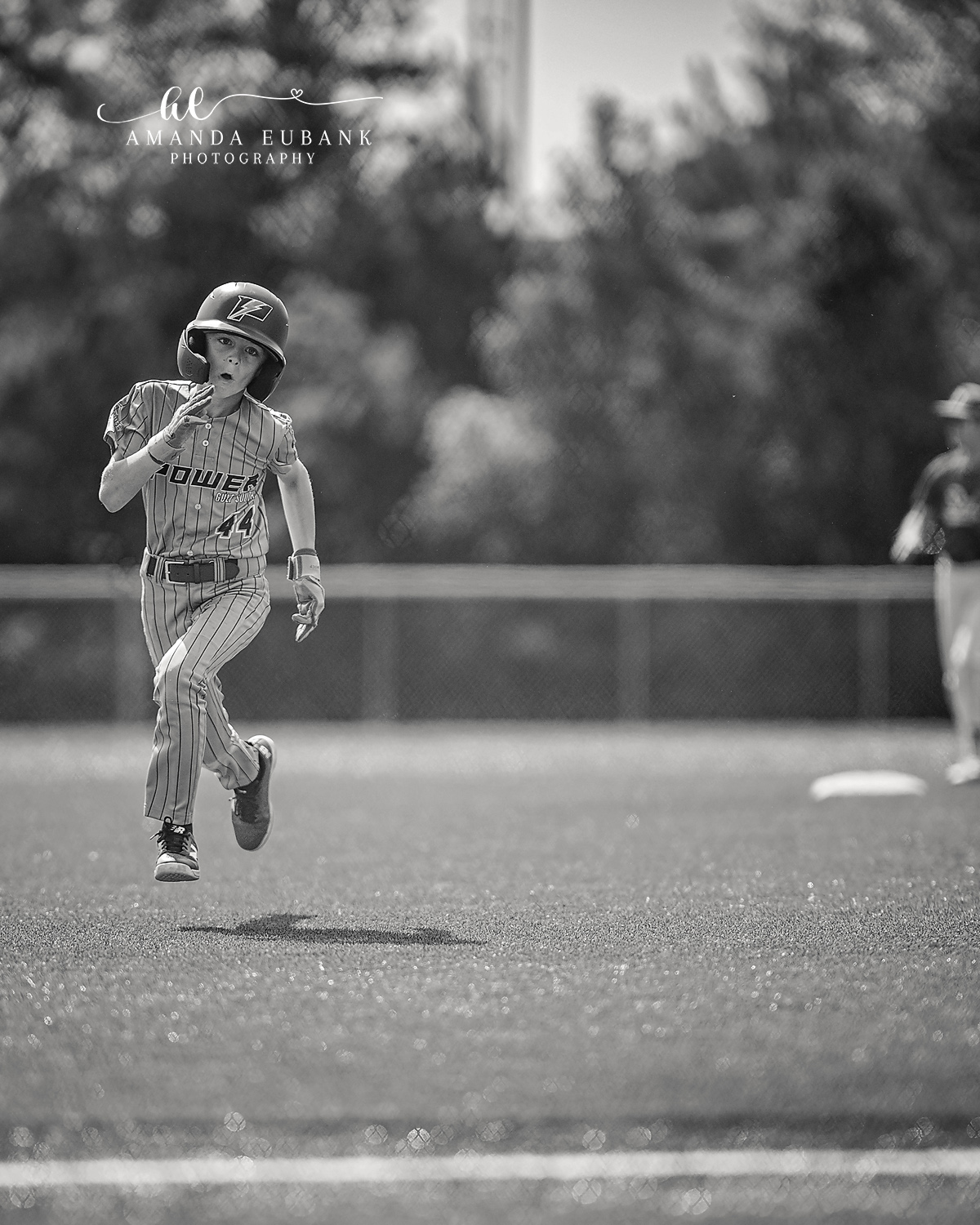Kilcrease 11U Base Runner Black and White | Power Baseball Gulf South Hoover AL Black and white image of Kilcrease 11U player number 44 in pinstripe Power Baseball jersey running the bases at a Hoover AL tournament