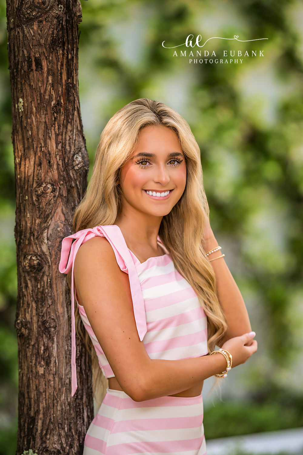 Tree Close-Up Senior Smile in Alys Beach | Alys Beach Senior Photographer Close-up of a smiling senior beside a tree in a pink-striped bow top, by Alys Beach Senior Photographer Amanda Eubank.