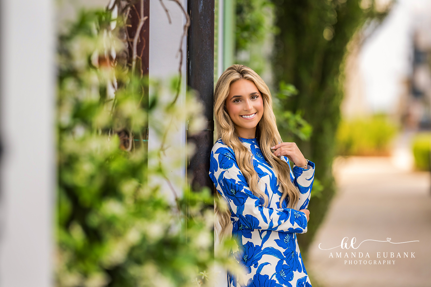 Senior Leaning by Jasmine Wall in Alys Beach | Senior Photographer in Alys Beach Senior in blue floral maxi leaning by a jasmine and ivy wall in Alys Beach, by Senior Photographer in Alys Beach Amanda Eubank.