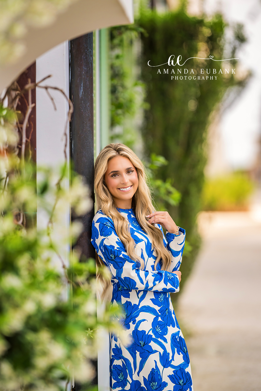 Foliage Archway Senior Portrait | Alys Beach Senior Photographer Senior in a blue floral maxi beneath an Alys Beach archway draped in foliage, by Alys Beach Senior Photographer Amanda Eubank.