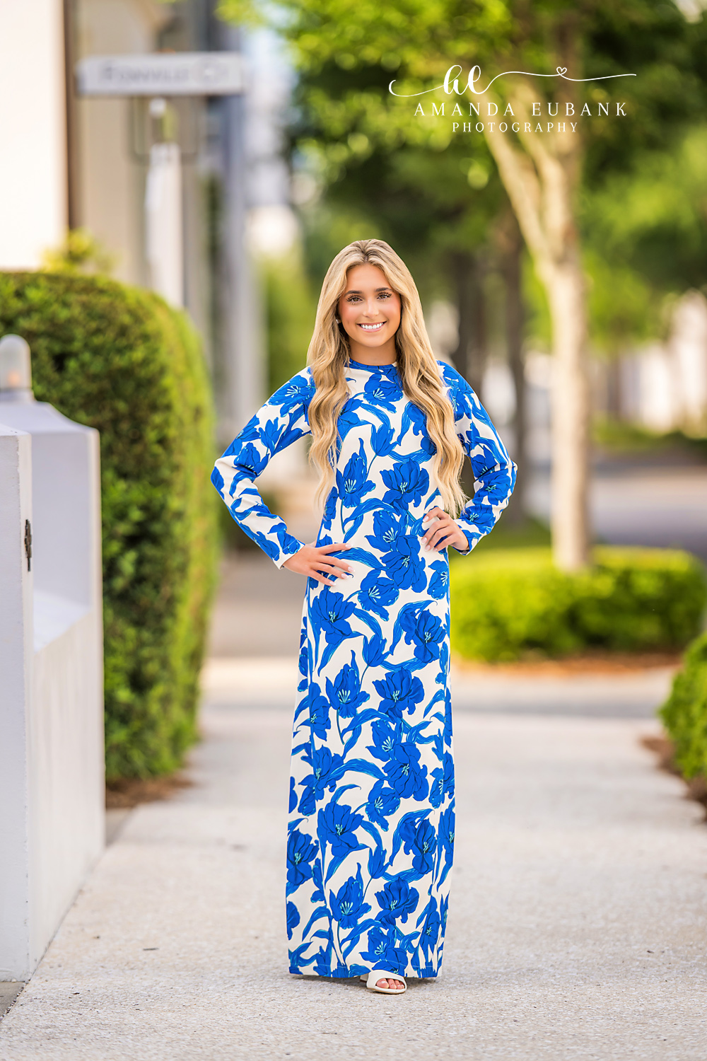 Blue Floral Maxi Senior Portrait | Alys Beach Photographer Senior in a blue floral maxi dress on a sun-drenched Alys Beach walkway lined with hedges, by Alys Beach Photographer Amanda Eubank.