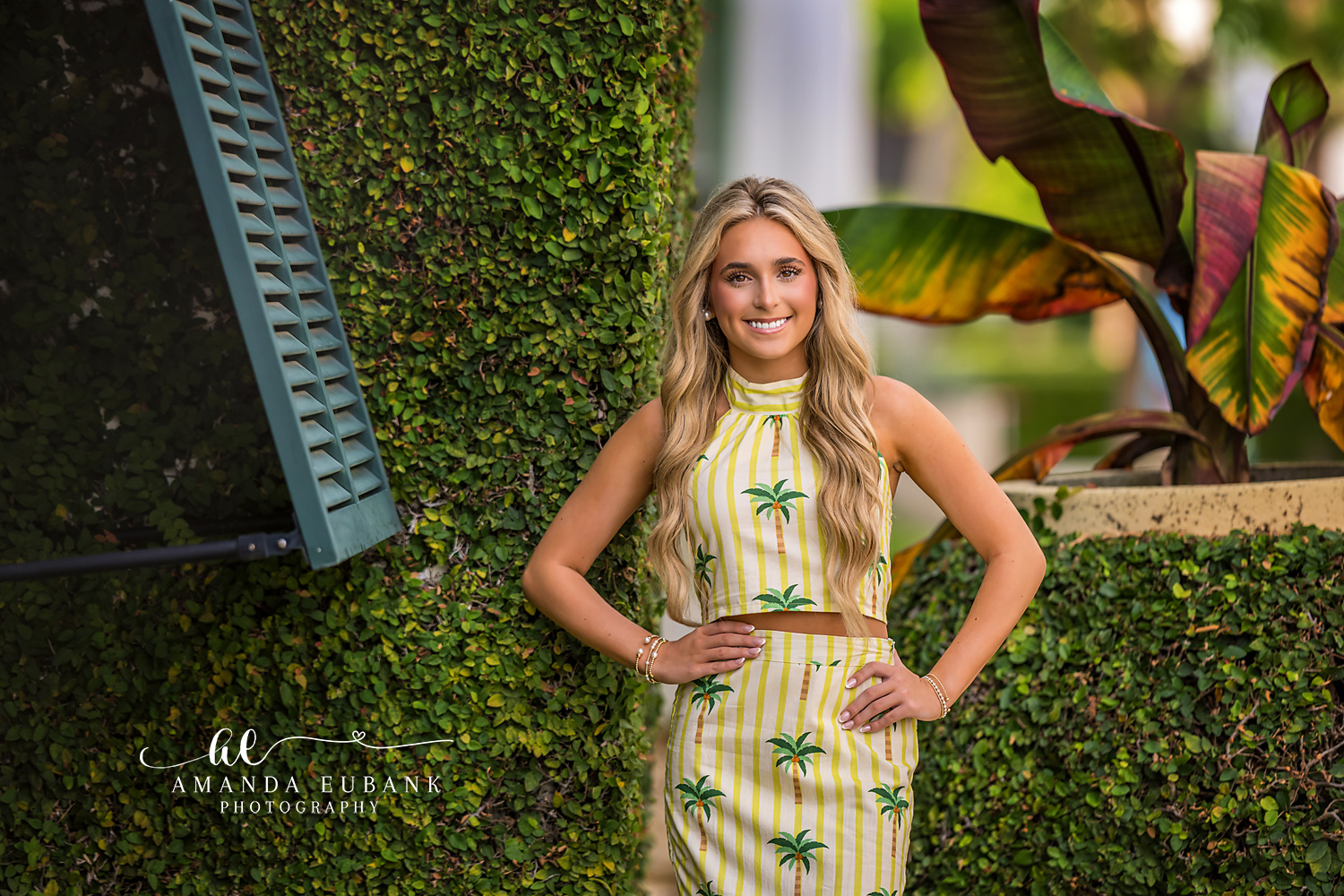 Green Shutters and Palms Senior Portrait | Alys Beach Senior Photographer Senior in a yellow palm-print outfit by green shutters and tropical foliage in Alys Beach, by Alys Beach Senior Photographer Amanda Eubank.