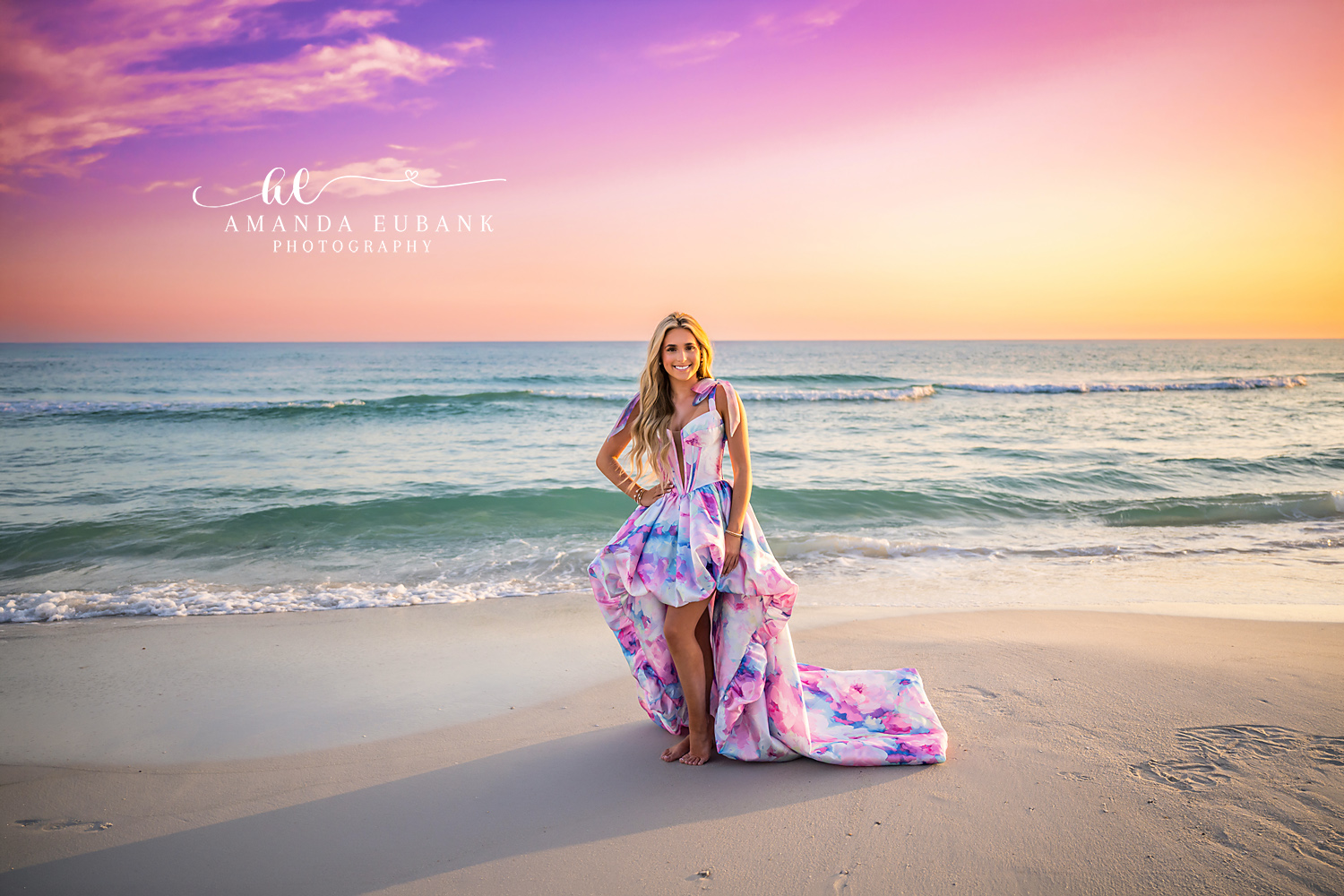 Sunset Beach Senior Portrait in Pastel Watercolor Gown | Senior Photographer in Alys Beach Senior posing on the sand in a pastel watercolor high-low gown at sunset with the Gulf behind her, by Senior Photographer in Alys Beach Amanda Eubank.