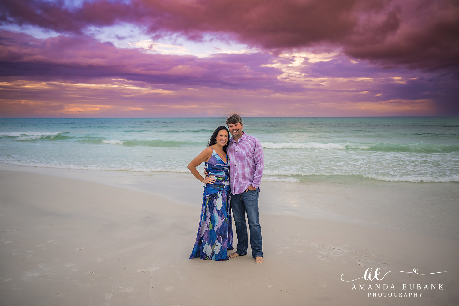 30A Couples Beach Portrait in Santa Rosa Beach, Florida Couple in a blue floral maxi dress and lavender shirt at the Seagrove Beach waterline at sunset