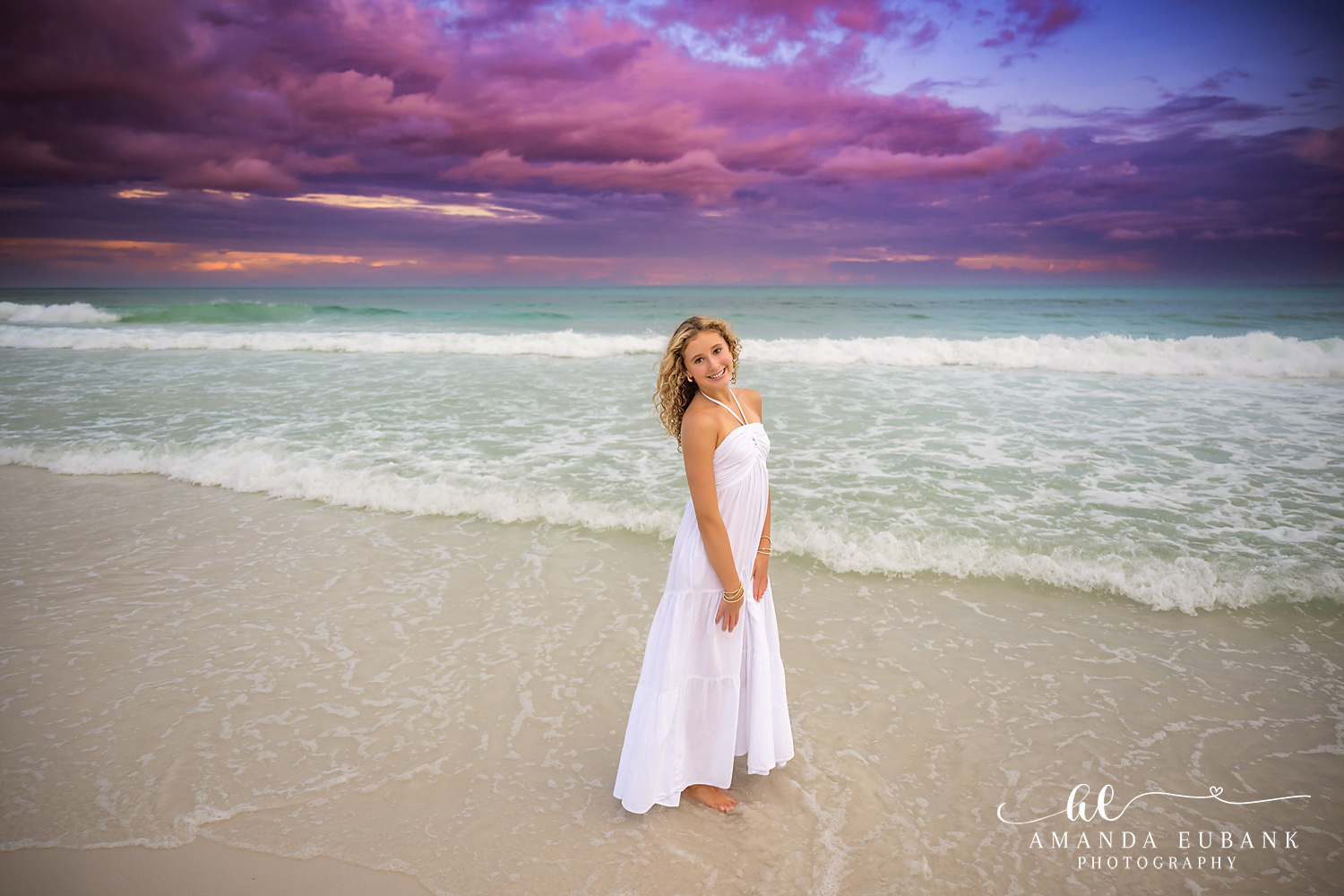 30A Beach Portrait – Walking the Shoreline in Santa Rosa Beach Girl in a white maxi dress standing in the Gulf shallows during a 30A sunset session