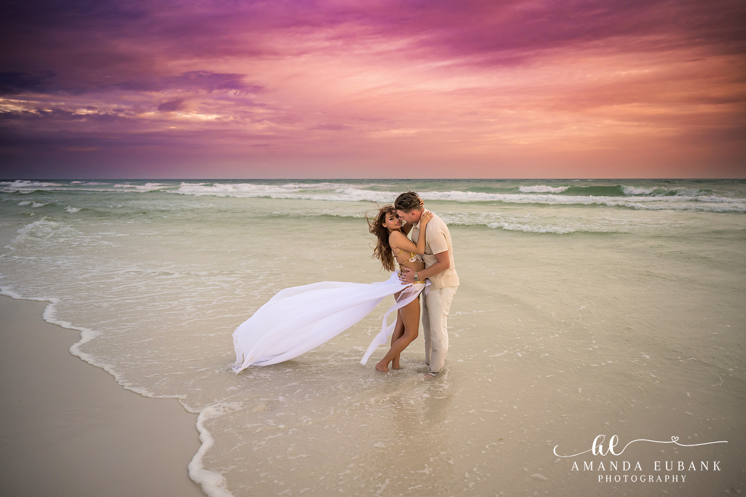 30A Couples Photographer – Dip Kiss Under a Purple Sky Couple embracing in the shallow surf during a 30A anniversary session at Dune Allen
