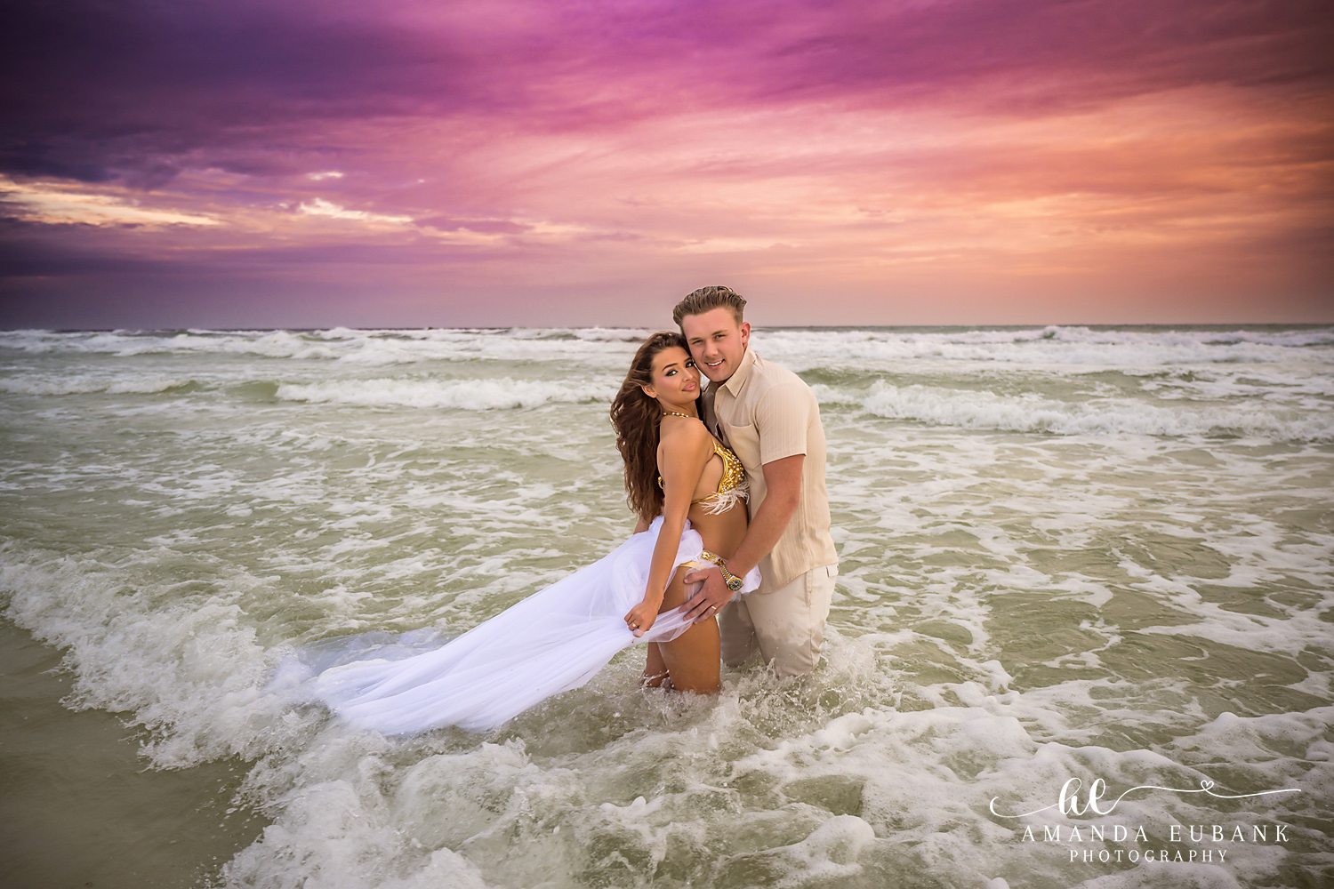 30A Couples Photos in the Emerald Gulf at Dune Allen Beach Couple soaked to the knees in the Gulf under a magenta sky at Dune Allen Beach
