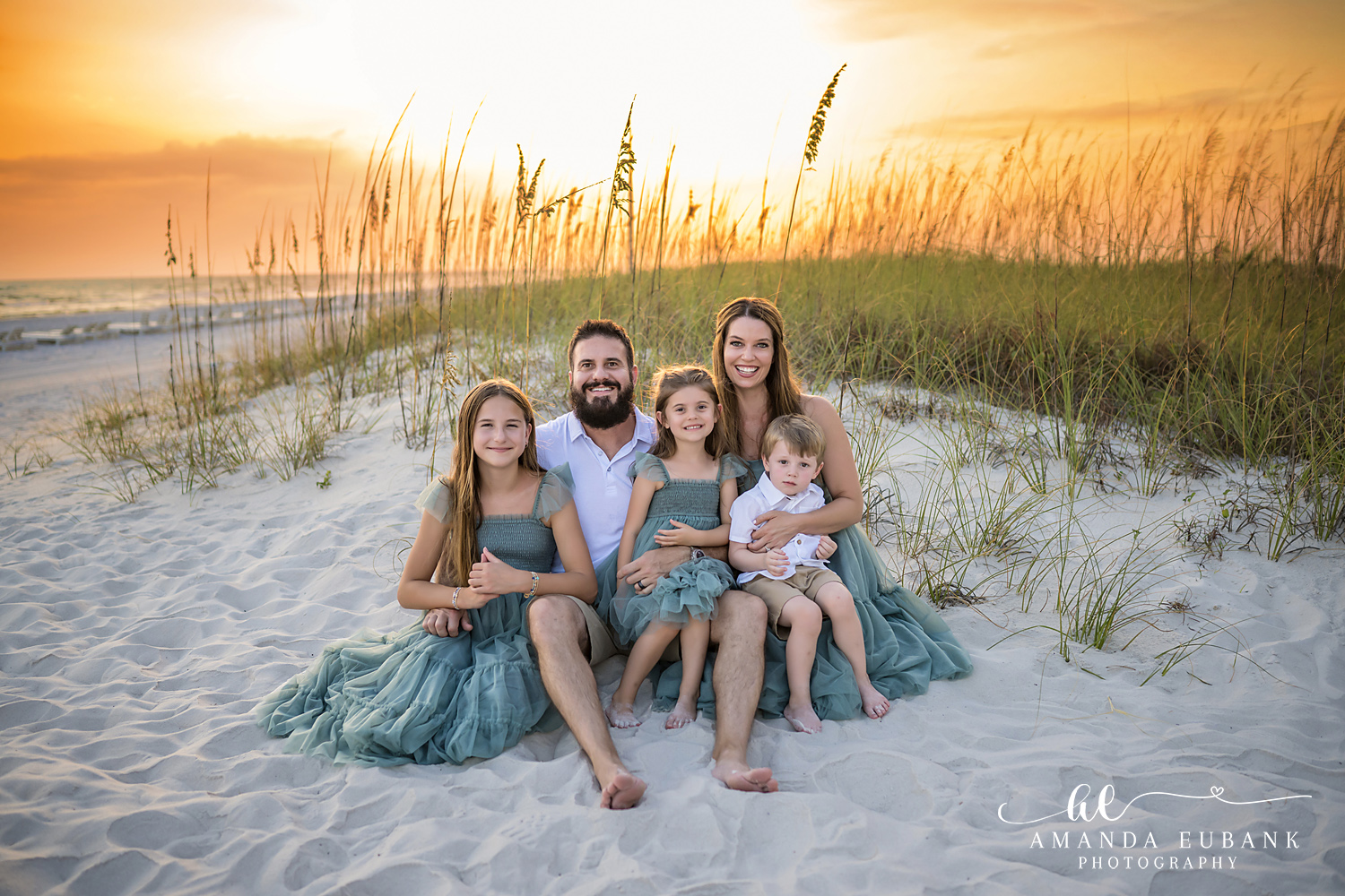 Family sitting together among the sand dunes in Carillon Beach, Florida
