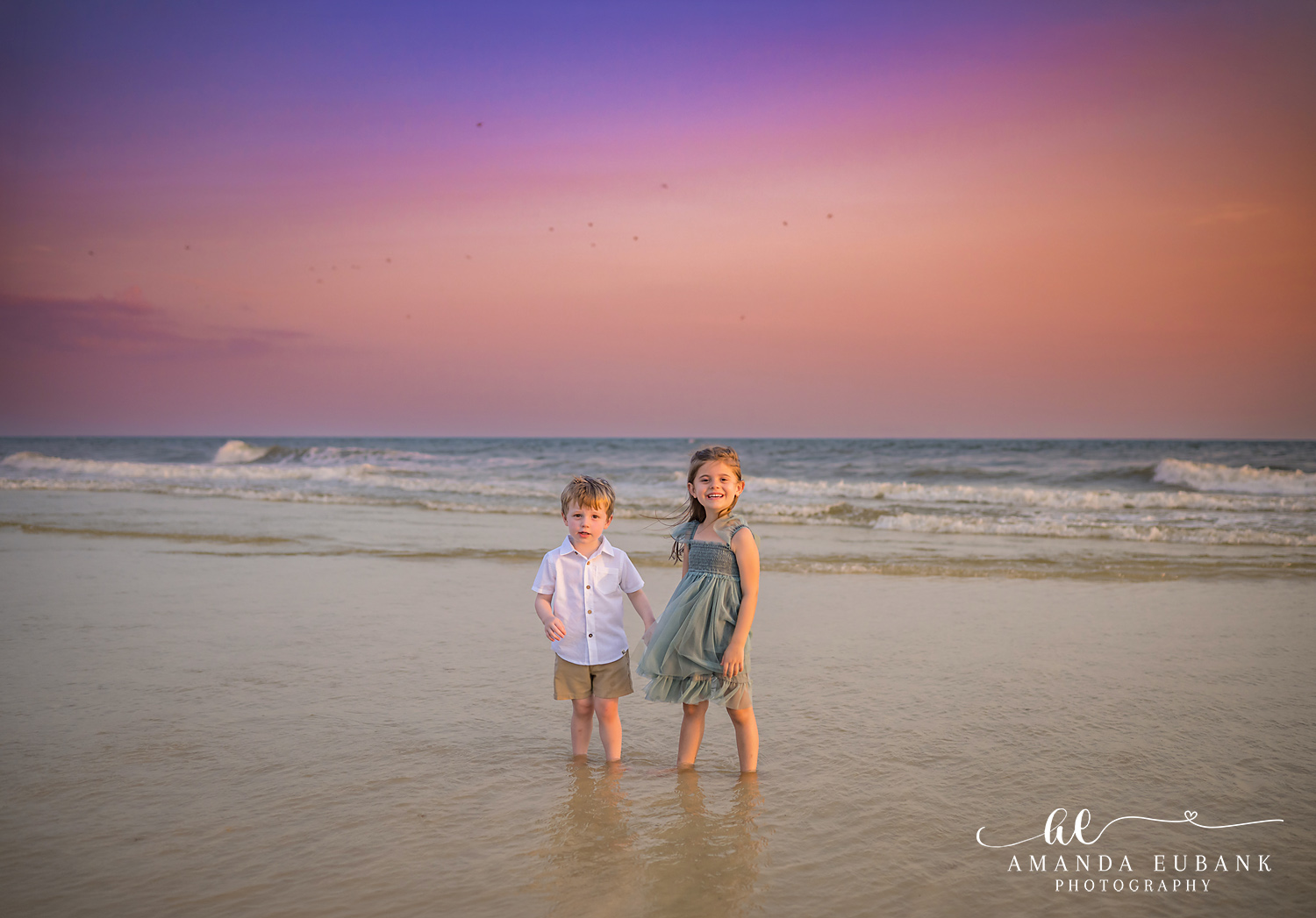 Carillon Beach Photographer – Siblings Holding Hands in the Surf Two young siblings holding hands while standing in shallow water in Carillon Beach, Florida