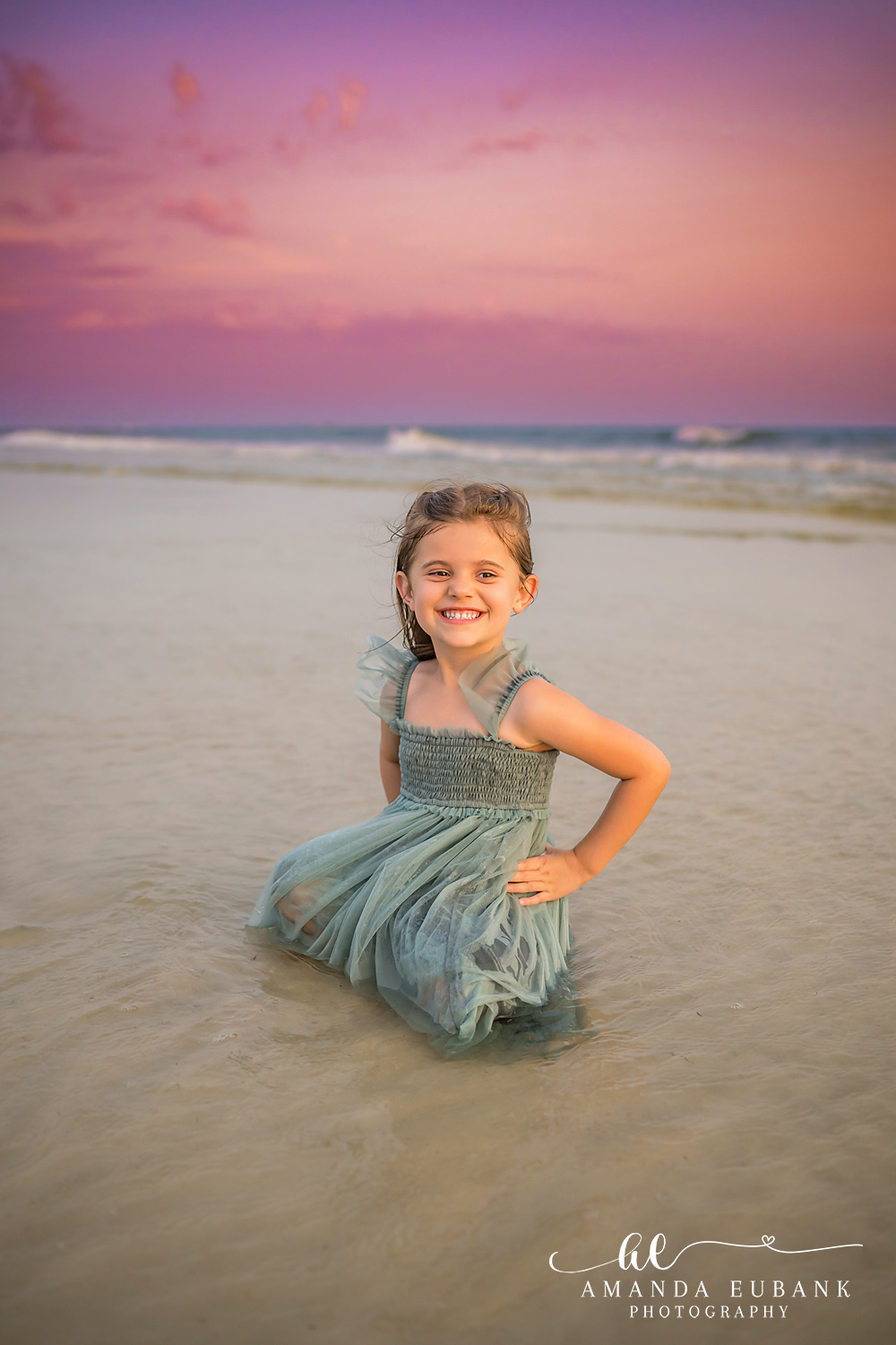 Carillon Beach Photographer – Splashing in the Surf Girl in a sage green dress smiling and standing in the surf in Carillon Beach, Florida