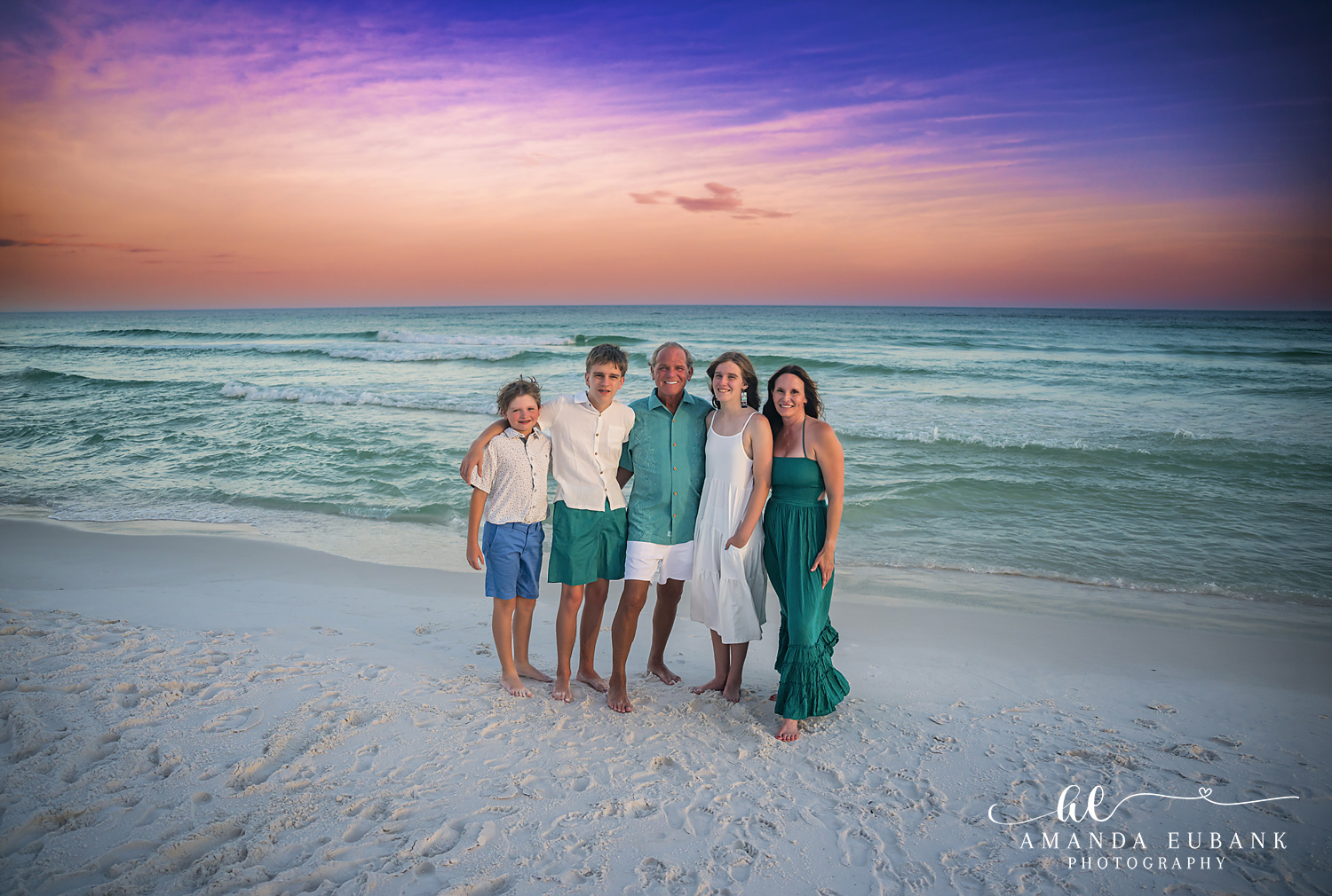 Destin Family Photographer – Family of Four on the Beach Family of four posing together on the beach in Destin, Florida at sunset