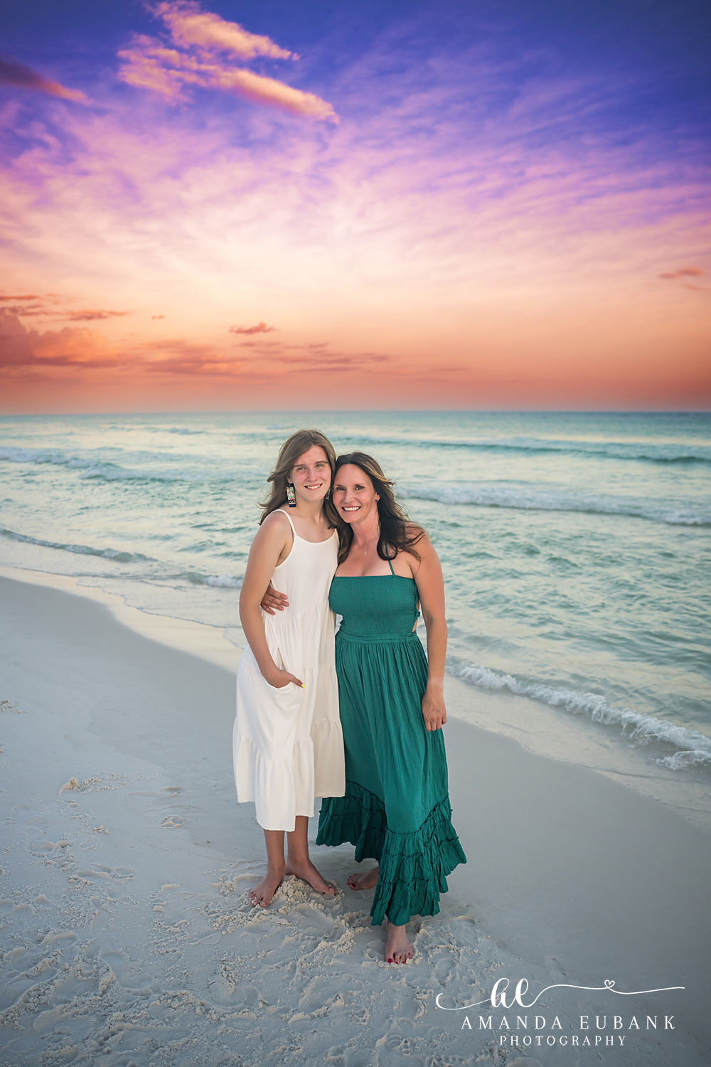 Destin Family Photographer – Mother and Daughter Sunset Stroll Mother and daughter standing together on the sand in Destin, Florida at sunset