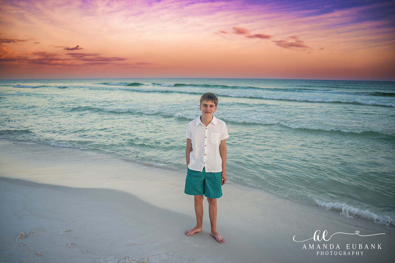 Destin Family Photographer – Son’s Portrait at Golden Hour Young boy standing on the beach in a white shirt at golden hour in Destin, Florida
