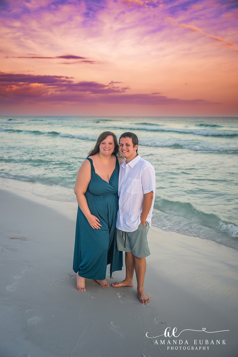 Destin Family Photographer – Teal Dress Couple Portrait Couple embracing on the beach, woman in a teal dress, in Destin, Florida