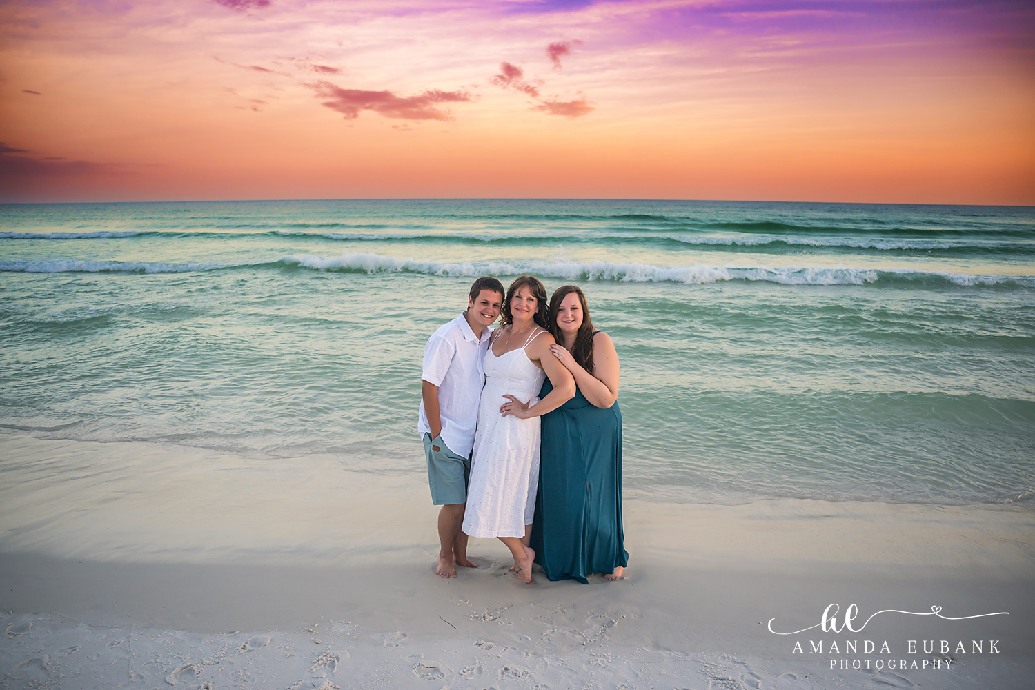 Destin Family Photographer – Embracing on the Shoreline Mother and daughters embracing on the beach in Destin, Florida