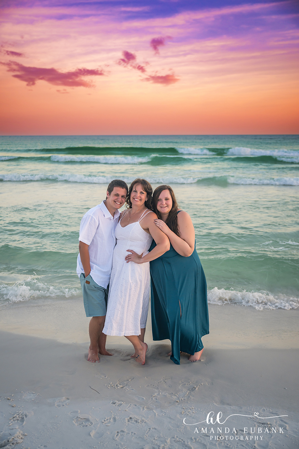 Destin Family Photographer – Mom and Daughters Together Mother posing with her daughters on the beach in Destin, Florida
