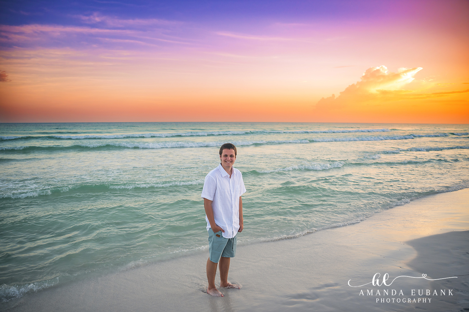Destin Family Photographer – Standing Beneath the Purple Sky Man standing alone on the beach under a purple and pink sunset sky in Destin, Florida