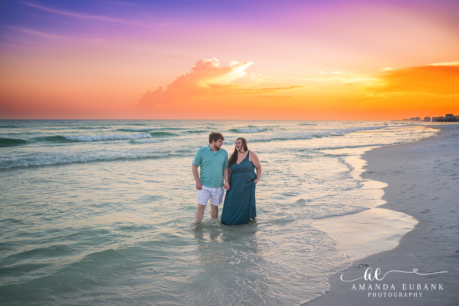 Destin Family Photographer – Couple on the Beach at Sunset Couple standing together on the beach under a colorful sunset sky in Destin, Florida