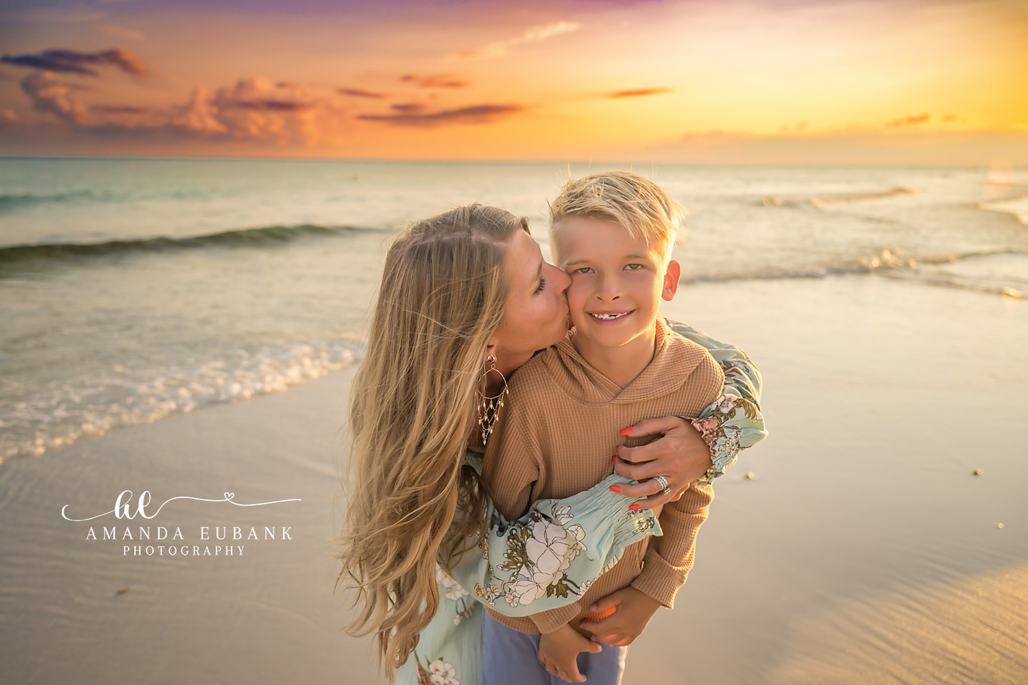 Destin Beach Family Session – Mother Kissing Her Son at Sunset Mother kissing her young son on the cheek at sunset during a Destin beach family photography session