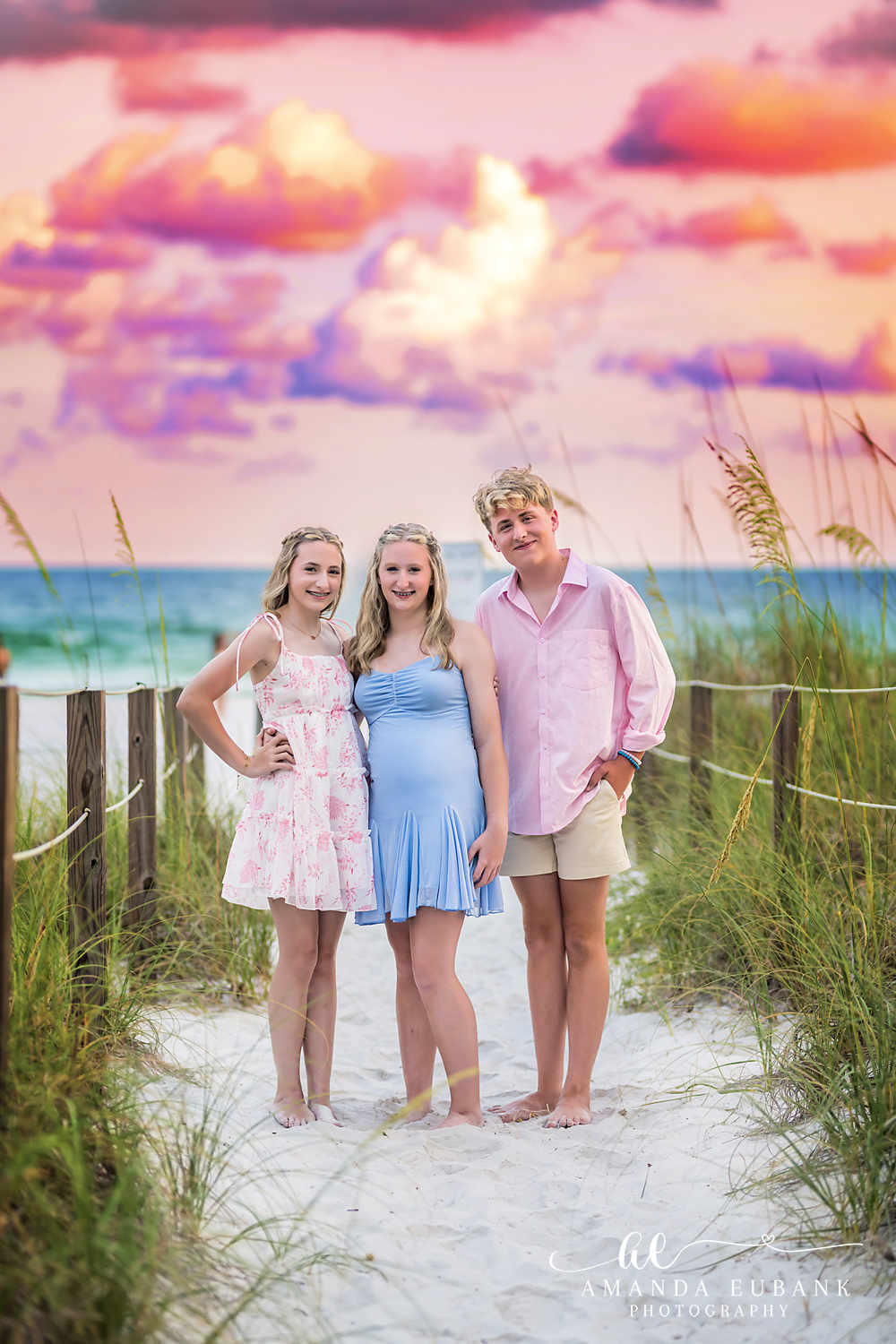Destin Florida Family Photographer – Mother and Daughters at Sunset Three family members among the sea oats at a Destin beach access during a pastel sunset