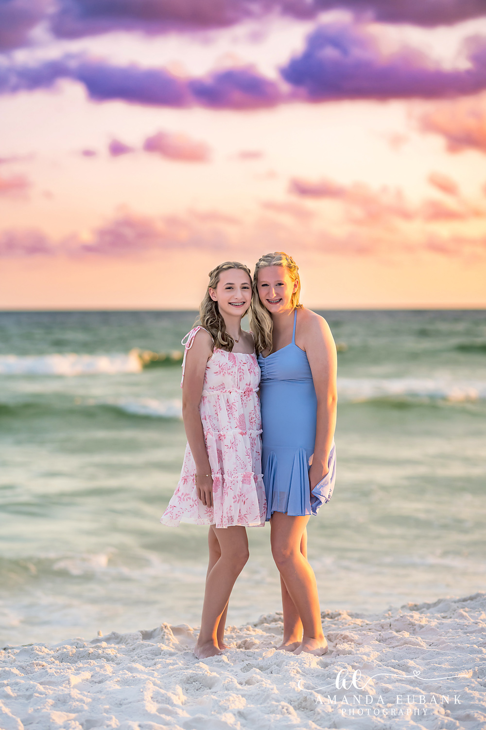 Destin Family Beach Photographer – Sisters at Sunset Two girls in pink and blue dresses at the edge of the Gulf during a Destin sunset session