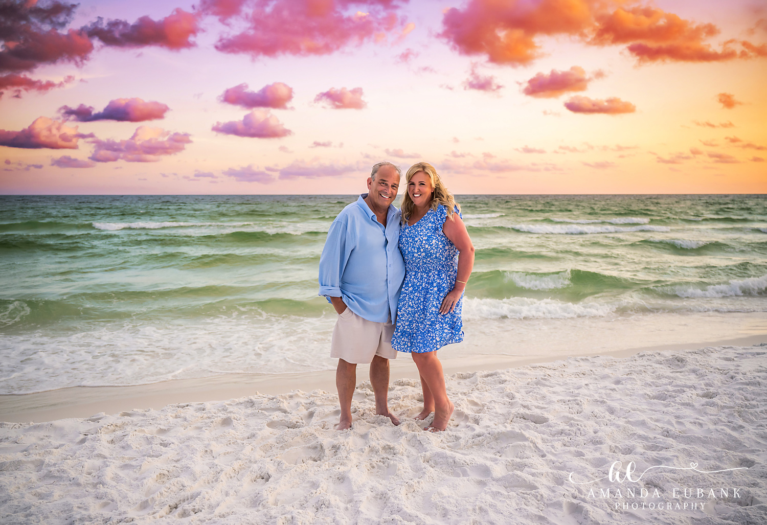 Destin Beach Anniversary Portrait of a Couple at Sunset Couple in blue standing together at the Destin waterline as the sun sets over the Gulf