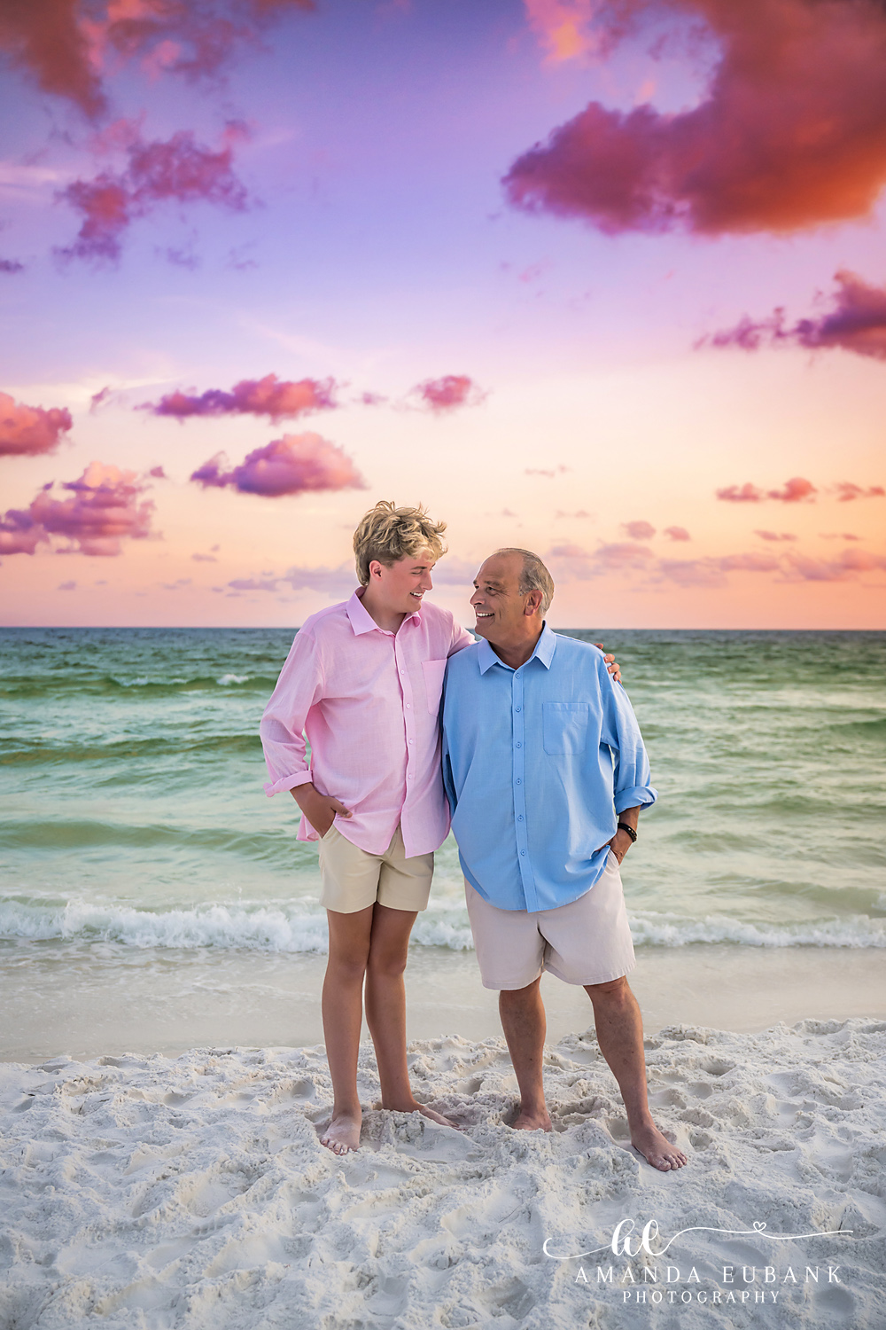 Candid Destin Beach Portrait – Laughing at Sunset Couple on the wet sand in Destin beneath towering pink and lavender sunset clouds