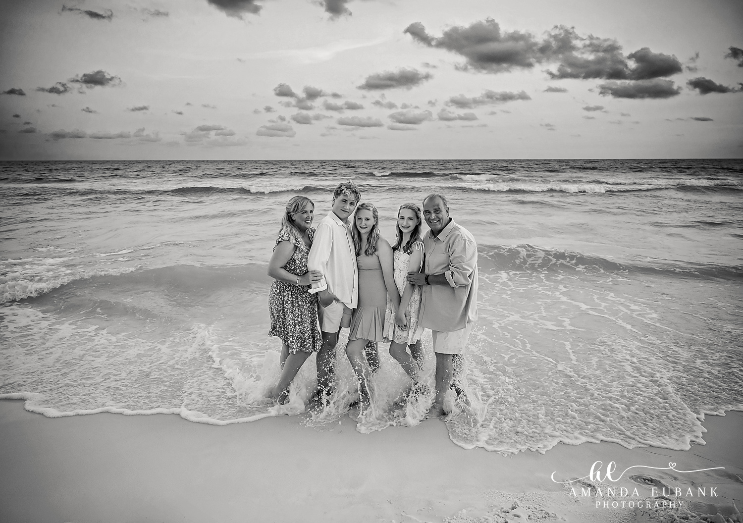 Black and White Destin Beach Family Photo in the Surf Black and white portrait of a family of five standing in the Destin surf at sunset