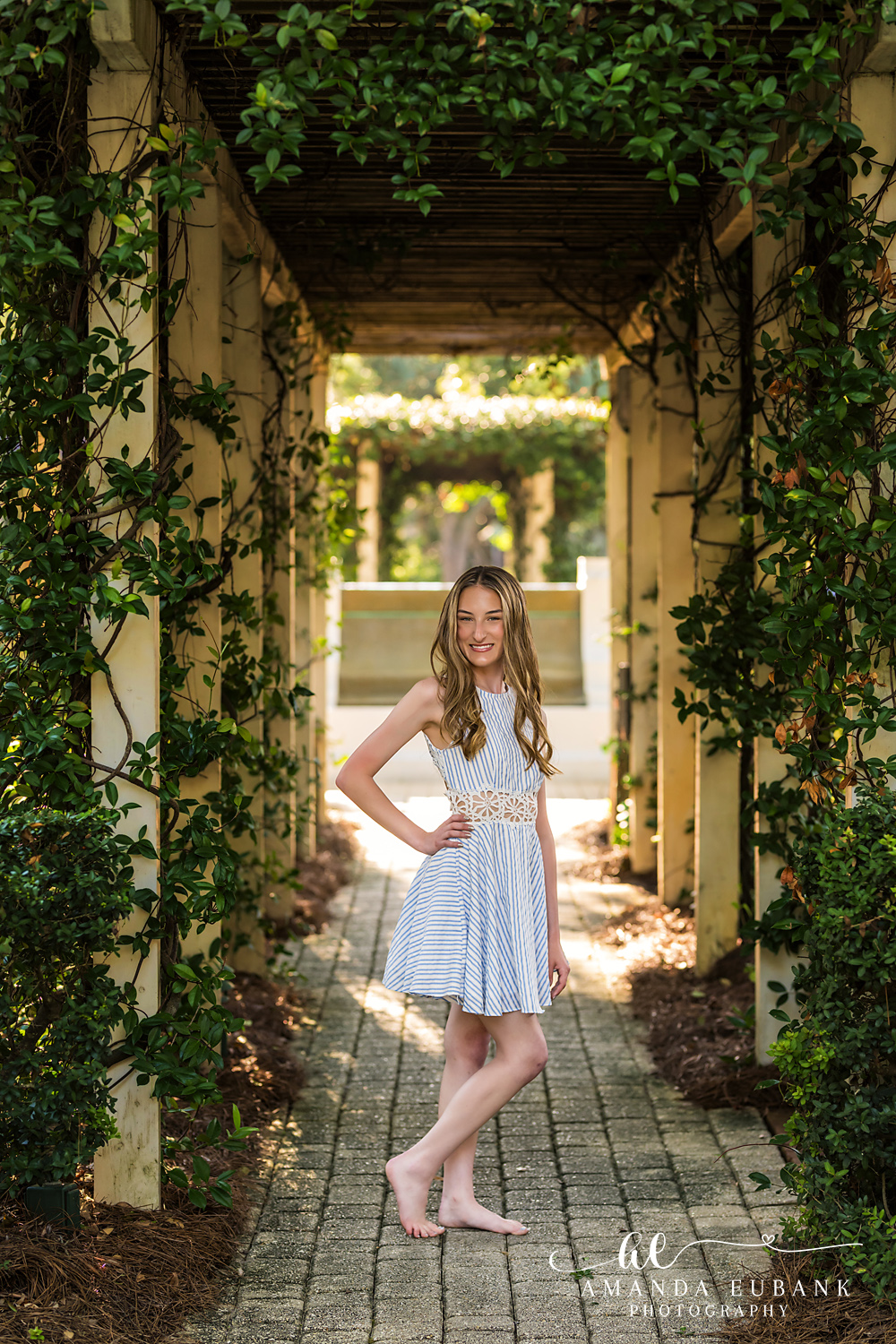 Rosemary Beach Senior Photographer – Light Blue Dress in the Trellis Walkway Senior girl in a light blue dress standing in a shaded garden trellis walkway in Rosemary Beach, Florida