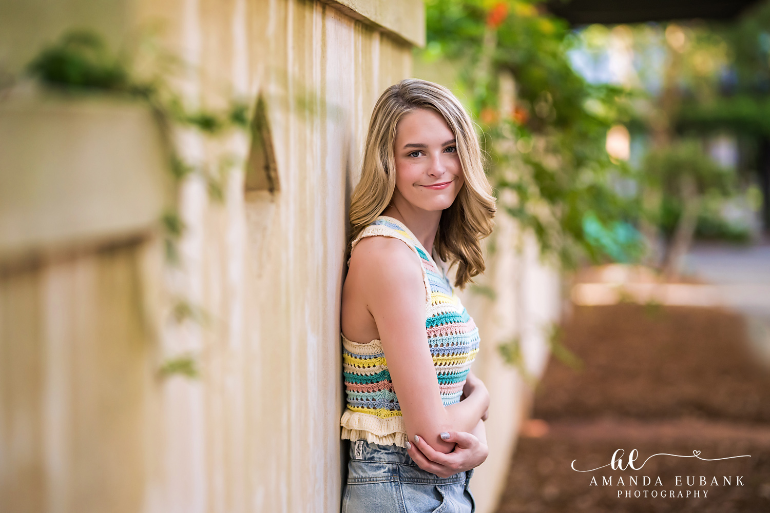 Rosemary Beach Senior Photographer – Garden Pathway Portrait Senior girl in a striped top standing on a garden pathway in Rosemary Beach, Florida
