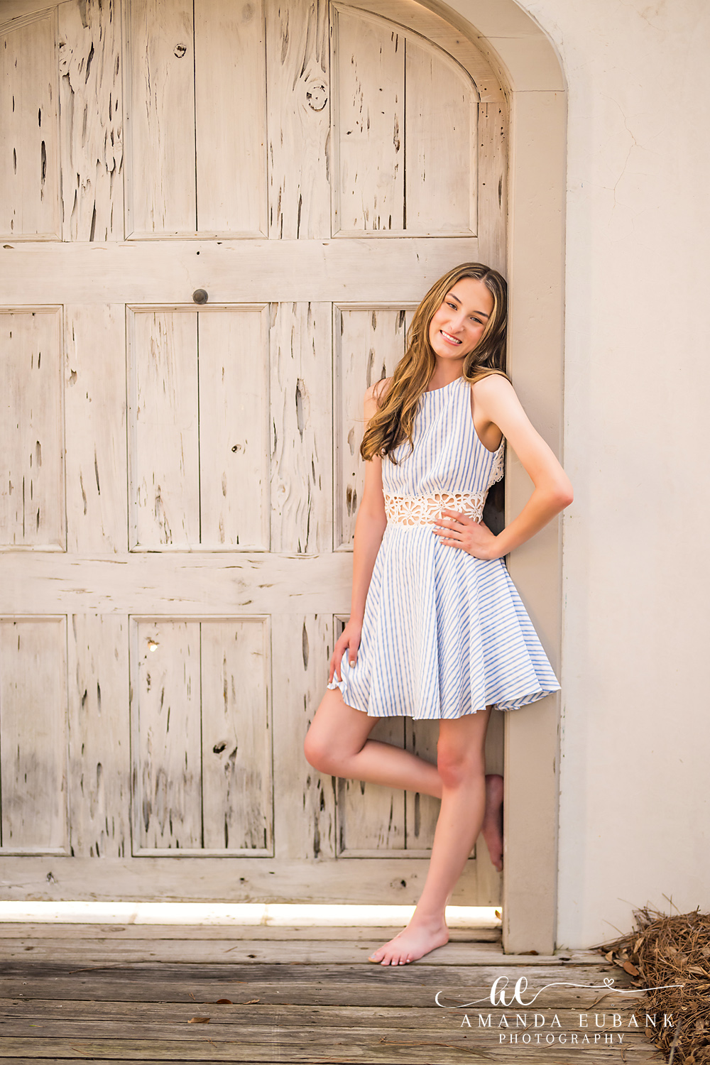 Rosemary Beach Senior Photographer – Light Blue Dress at the Door Senior girl in a light blue dress standing at a rustic wooden door in Rosemary Beach, Florida