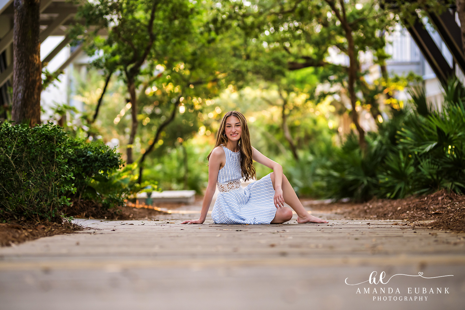 Rosemary Beach Senior Photographer – Light Blue Dress on the Boardwalk Senior girl in a light blue dress sitting on a wooden boardwalk path in Rosemary Beach, Florida