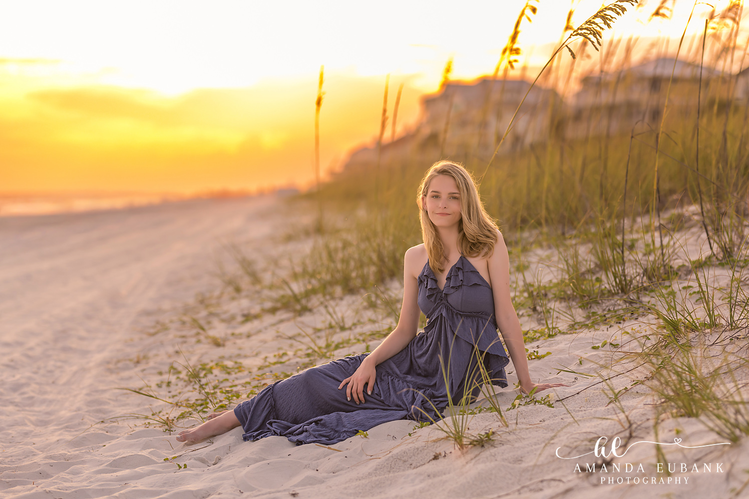 Rosemary Beach Senior Photographer – Seated in the Sand Dunes Senior girl in a navy dress sitting among the sand dunes at sunset in Rosemary Beach, Florida