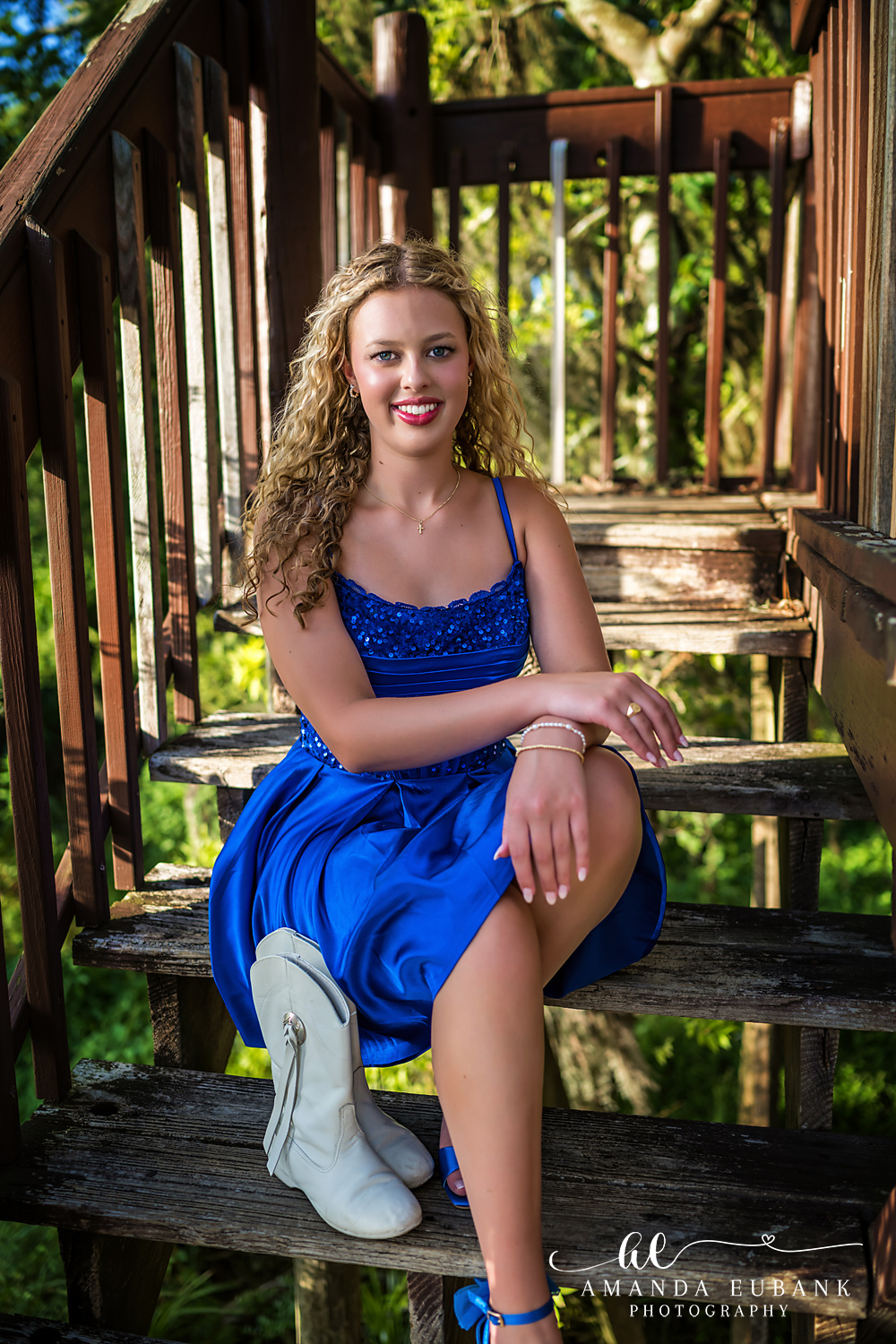 Sandestin Senior Photographer – Seated Portrait on the Boardwalk Stairs Senior girl seated on wooden boardwalk stairs in a blue dress in Sandestin, Florida