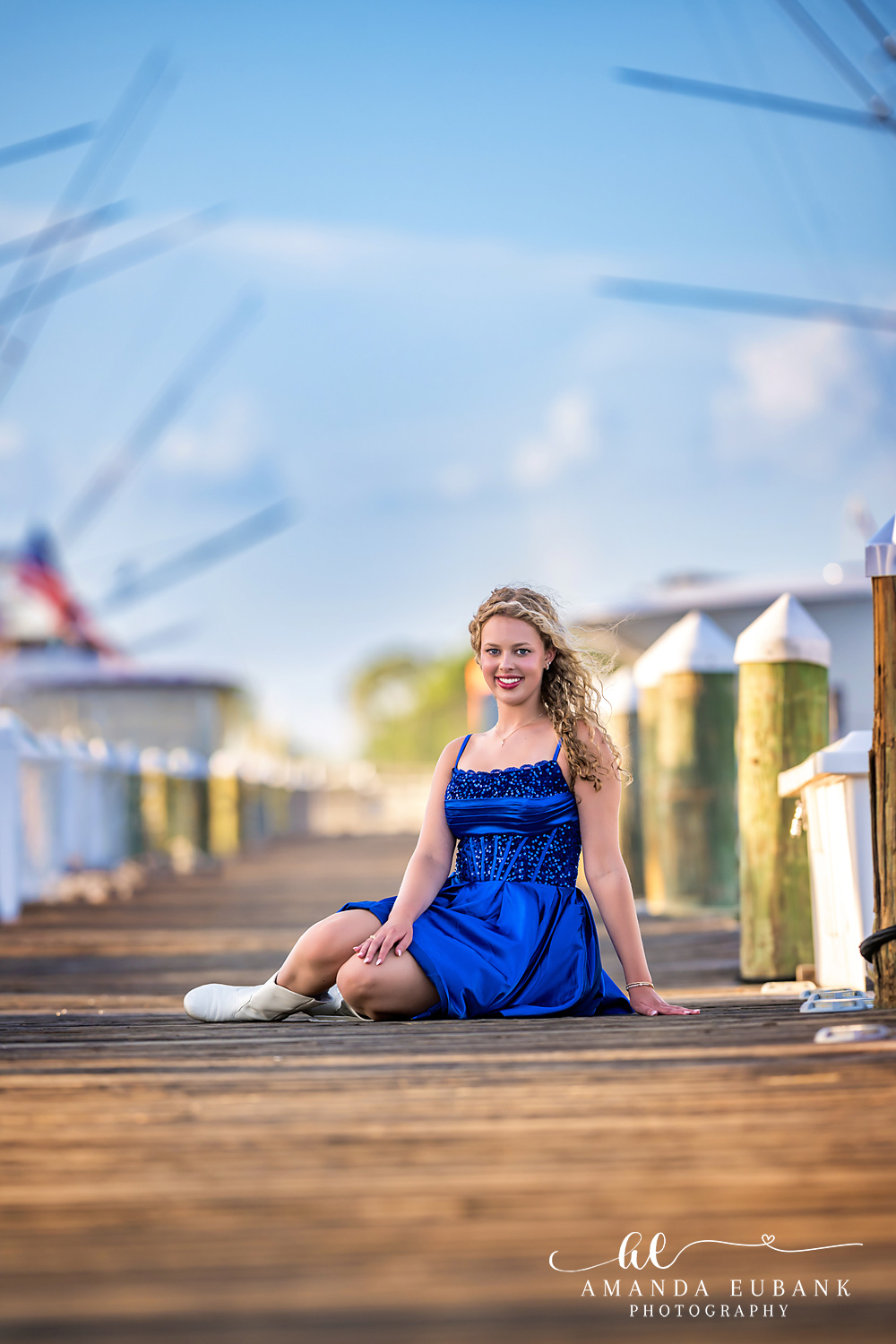 Sandestin Senior Photographer – Approaching the Beach Cabanas Senior girl walking toward colorful beach cabanas on a boardwalk in Sandestin, Florida