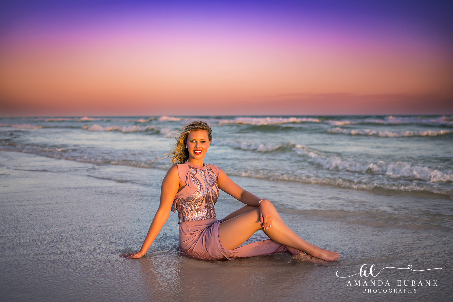 Sandestin Senior Photographer – Full-Length Sunset Silhouette High school senior standing on the beach in a pink dress under a purple sunset sky in Sandestin, Florida