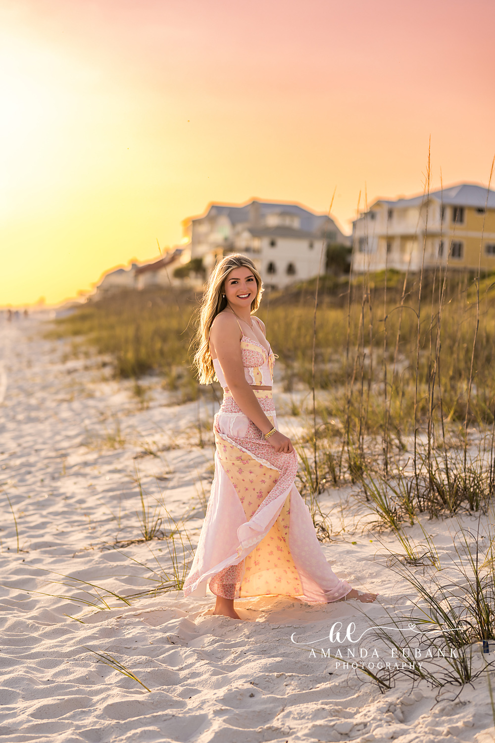 Santa Rosa Beach Senior Session – Blush Gown in the Dunes High school senior in a blush lace gown standing in the dunes at sunset during a Santa Rosa Beach senior photography session