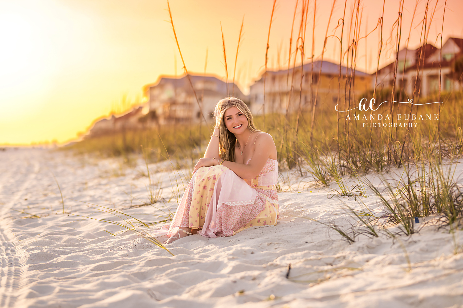 Santa Rosa Beach Senior Session – Seated in the Dunes at Golden Hour High school senior in a blush gown seated in the white sand dunes among sea oats at sunset in Santa Rosa Beach