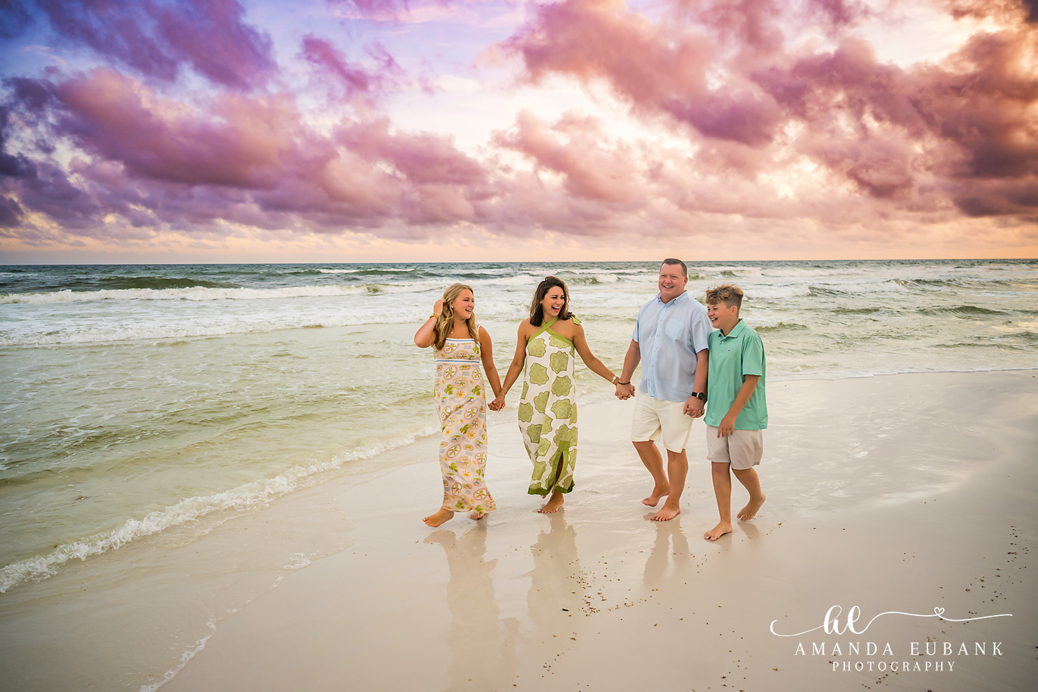 Family of three walking together along the shoreline in Seaside, Florida