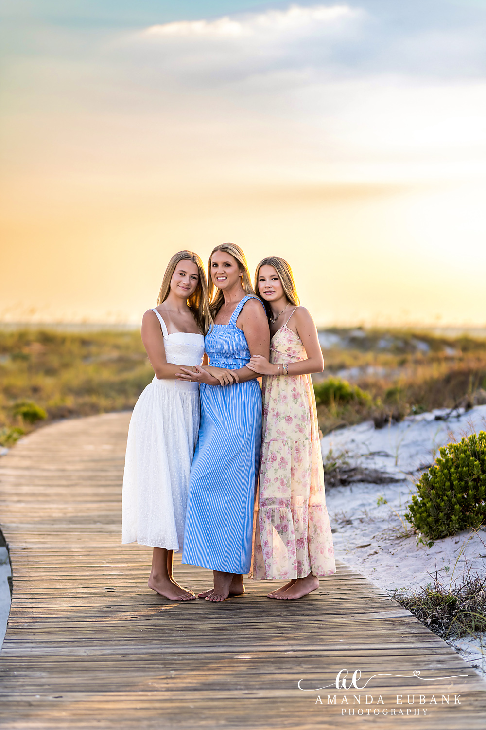 WaterSound Beach Mother-Daughters Sunset Portrait Mother embracing her two daughters on the boardwalk at WaterSound Beach at sunset