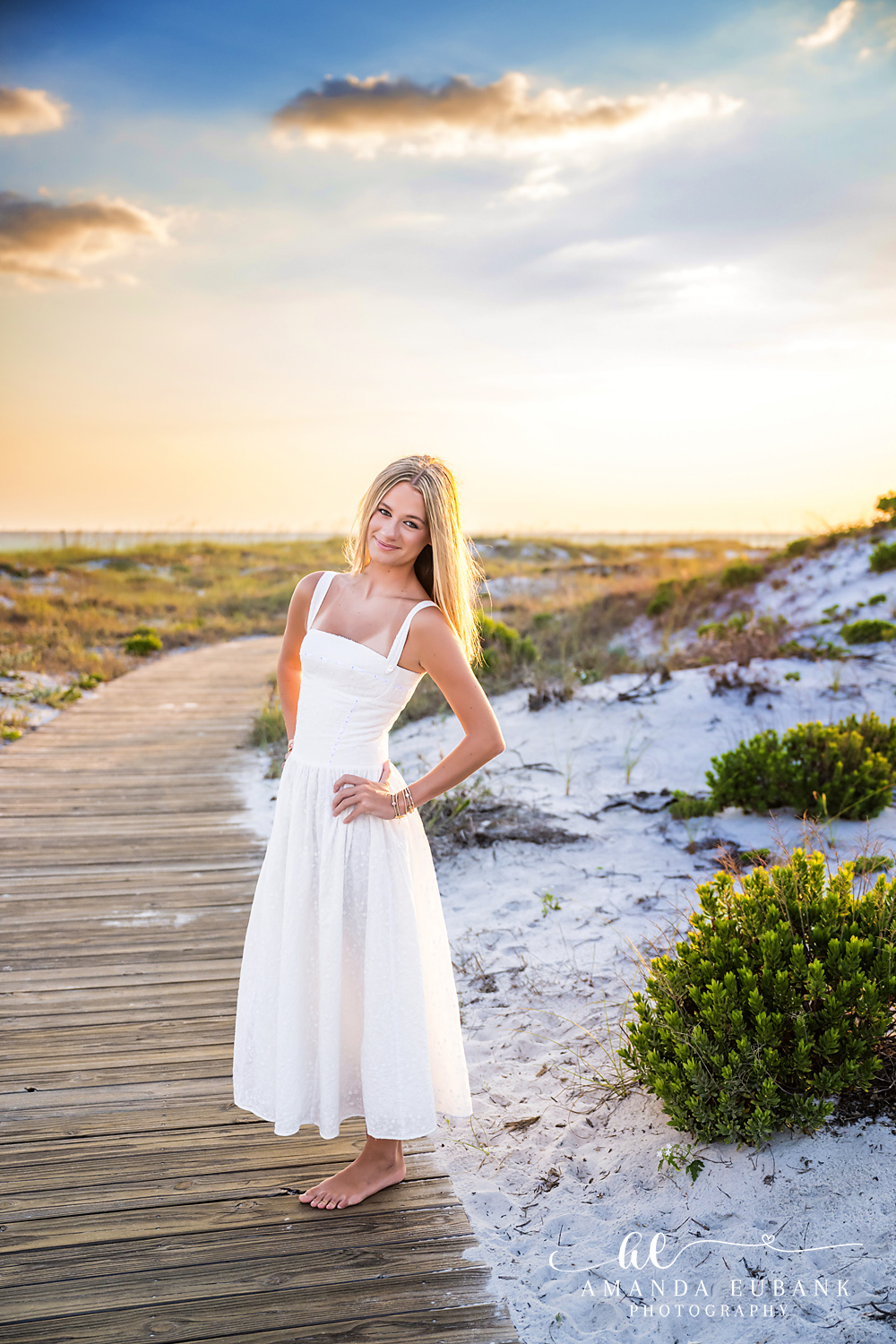 WaterSound Beach Full-Length Sunset Portrait Young woman in a white sundress posing confidently on the boardwalk at WaterSound Beach