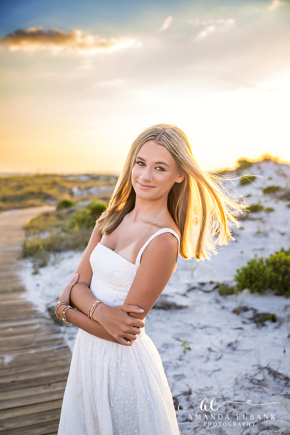 WaterSound Beach Sunset Portrait on the Boardwalk Young woman in white dress standing on the beach boardwalk with sunlight streaming through her hair