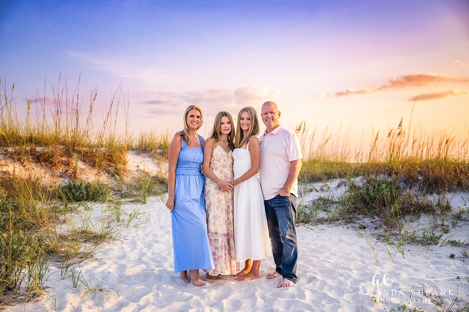 WaterSound Beach Family Photo Session Among Sea Oats Family of four smiling together among the sea oats at WaterSound Beach at dusk