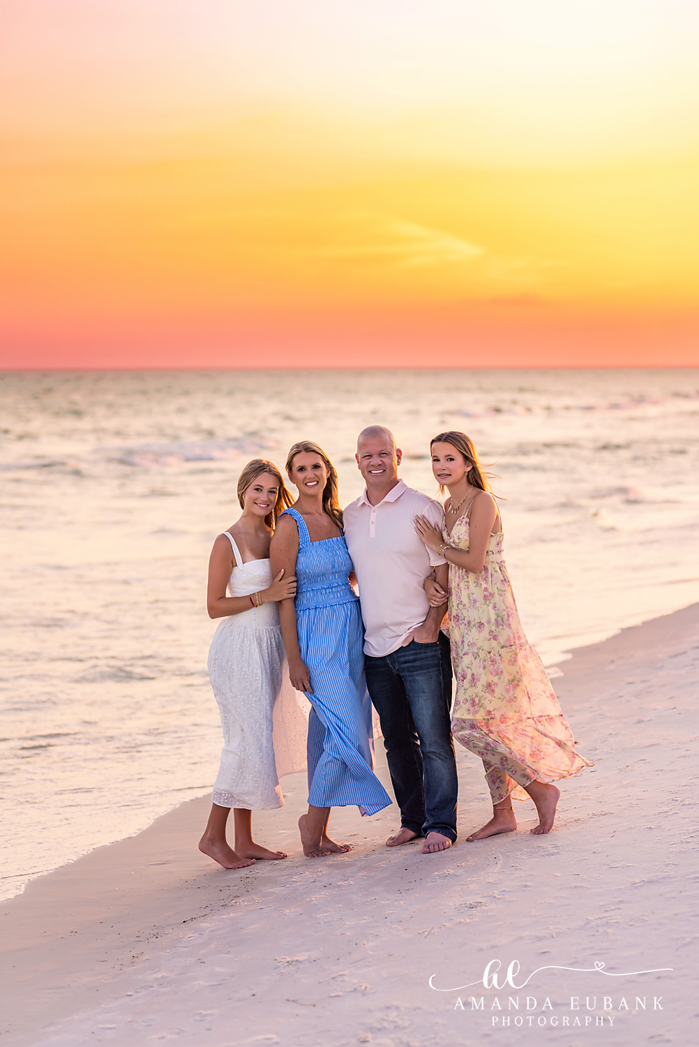 WaterSound Beach Family Portrait at Sunset Family of four embracing on the beach at sunset during a WaterSound Beach family portrait session