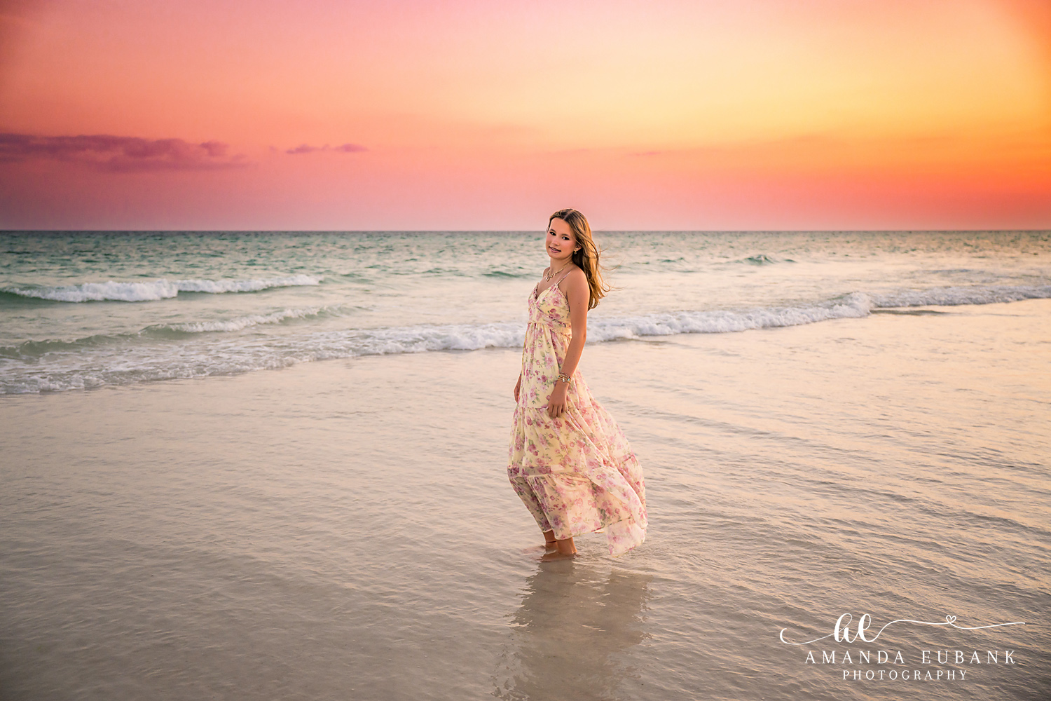 WaterSound Beach Sunset Portrait – Golden Hour by the Waves Young woman glancing over her shoulder while wading in the ocean waves at sunset on WaterSound Beach